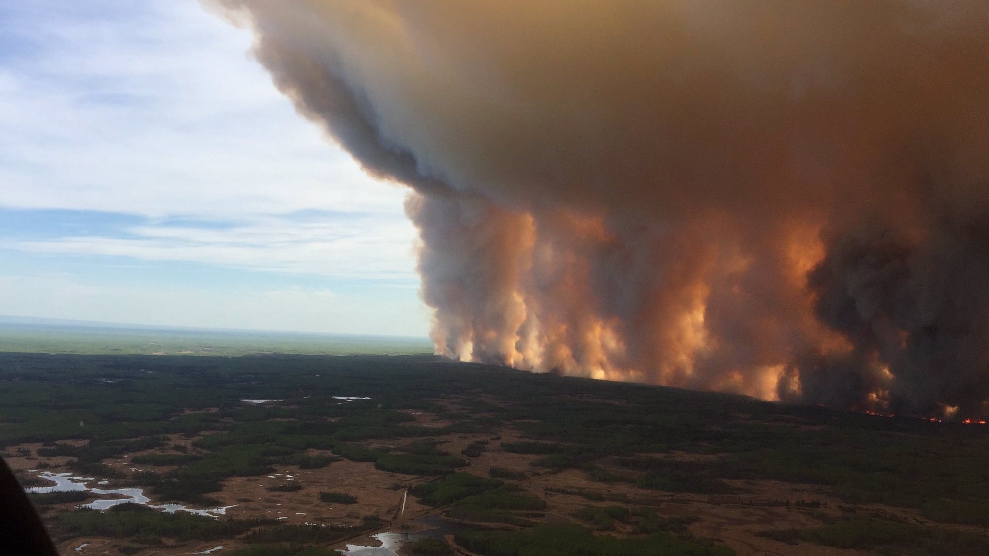 epa07593077 A handout photo made available by Alberta Wildfire shows smoke rising from a wildfire in Chuckegg Creek, Southwest of High Level, Alberta, Canada, 19 May 2019 (Issued 22 May 2019). According to reports on 20 May, more than 100 thousand acres burnt due to the Chuckegg Creek fire, seven miles southwest of High Level town in Alberta, Canada.  EPA/ALBERTA WILDFIRE HANDOUT  HANDOUT EDITORIAL USE ONLY/NO SALES