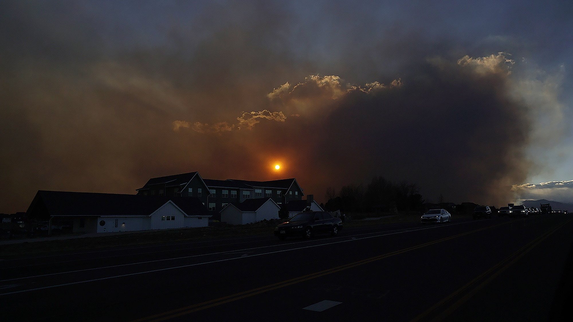 epa09660973 Smoke rising from grass fires near Boulder, Colorado shroud the sun as seen from 119th Street in Lafayette, Colorado, USA, 30 December 2021. Officials have ordered the evacuation of two towns ahead of the fires reportedly started by downed power lines in extremely strong winds.  EPA/RAY STUBBLEBINE