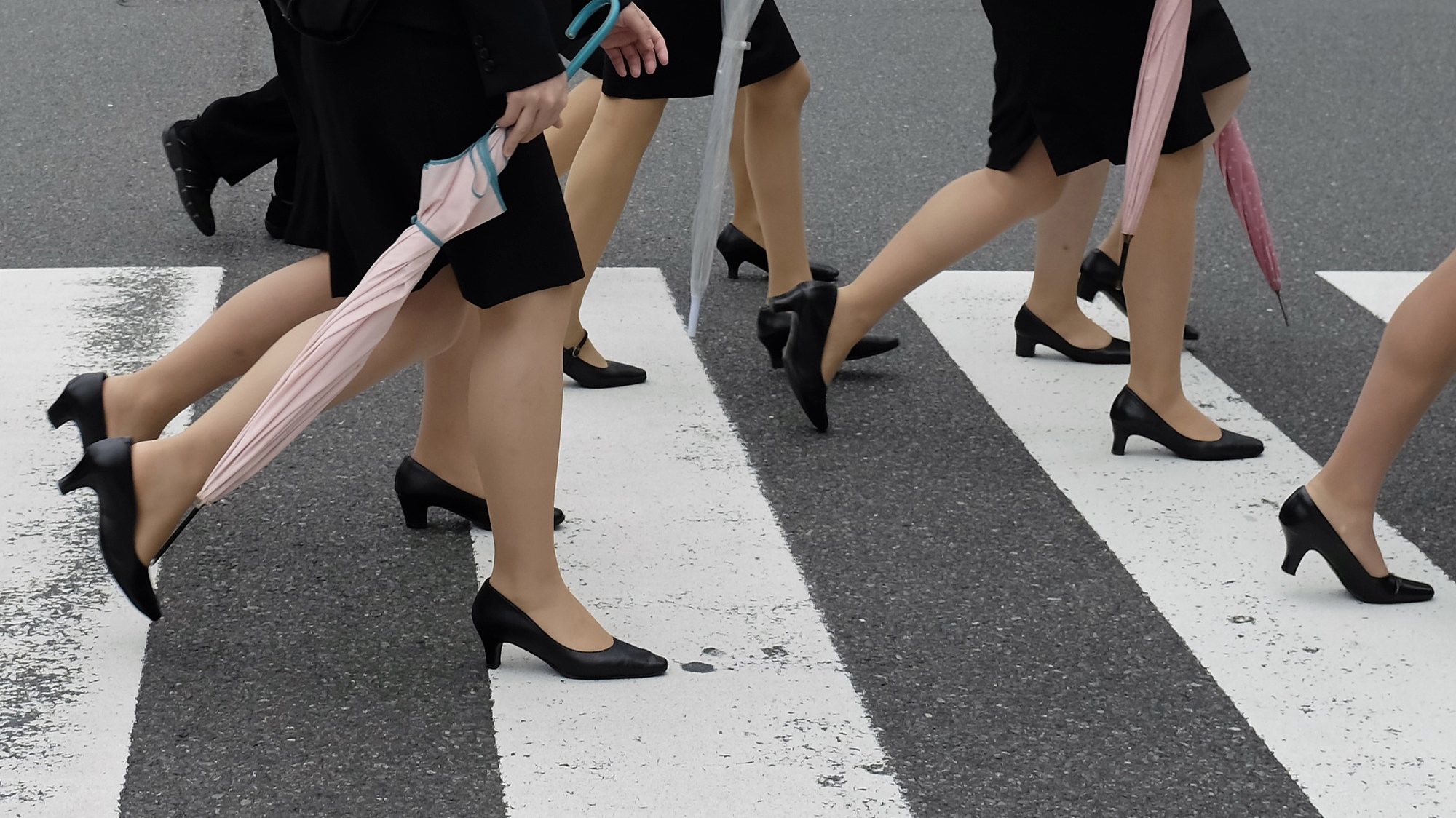 epa07435736 (FILE) - Young women wearing dark suits worn by new employees cross a street in Tokyo, Japan, 01 October 2013 (reissued 14 March 2019). According to media reports, as a budding movement to address inequality in the workplace develops in Japan, some women are campaigning to bring attention in inequities in guidelines for workplace attire, specifically the expectation that women wear high heels to work. The footwear is notorious for being generally uncomfortable and can cause bruising and blisters. The campaign uses the moniker #KuToo - a reference to the #MeToo gender equality movement - which is a fusion of the Japanese words for shoe (kutsu) and pain (kutsuu).  EPA/FRANCK ROBICHON
