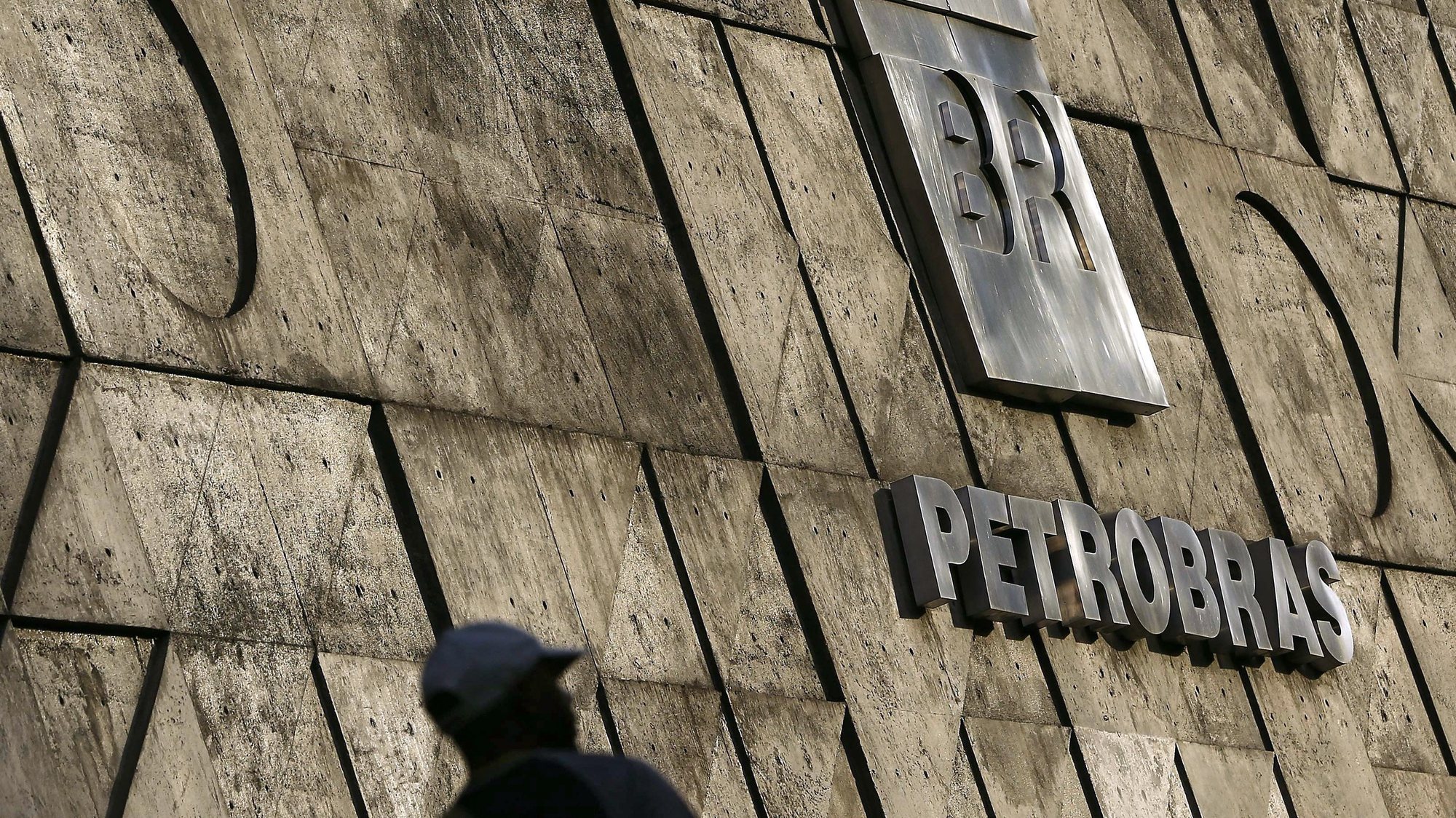 epa08423242 (FILE) - A person walks past a sign at the headquarters of state-run oil company Petrobras in Rio de Janeiro, Brazil 24 April 2015 (reissued 15 April 2020). According to media reports, Petrobras posted a net loss of 8.35 US dollars for its first quarter.  EPA/MARCELO SAYAO