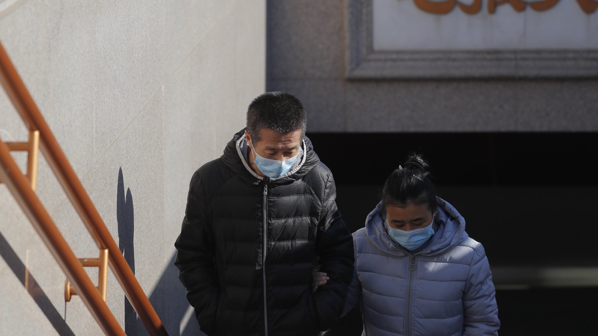 epa08892973 People wearing protective face masks walk out of an underpass in Beijing, China, 19 December 2020. China reported 17 newly confirmed coronavirus disease (COVID-19) cases on Chinese mainland on 18 December, including three domestically transmitted cases, two of which in Beijing, according to China&#039;s National Health Commission.  EPA/WU HONG