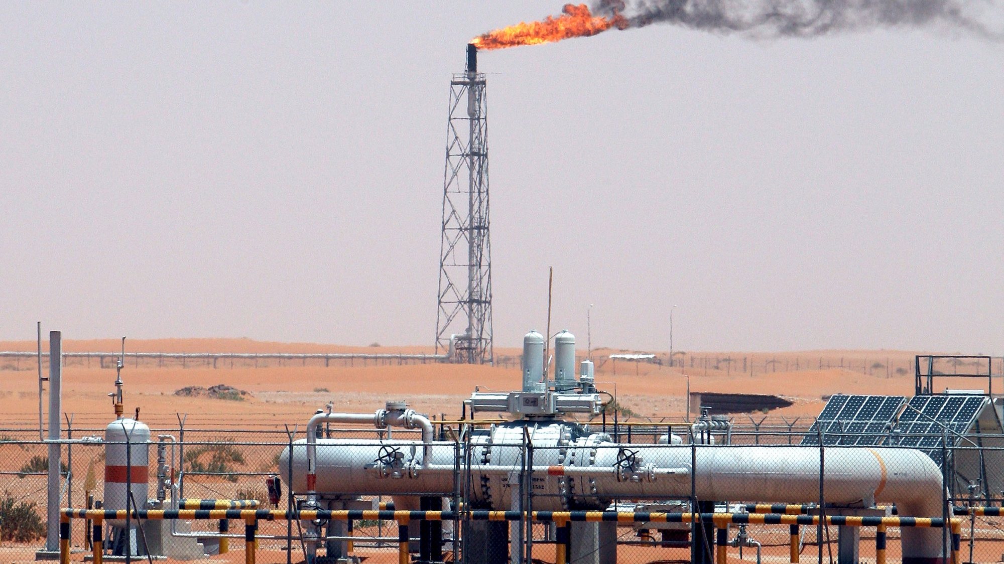 epa09087338 (FILE) - A gas flame behind pipelines in the desert at Khurais oil field, about 160 km from Riyadh, Kingdom of Saudi Arabia, 23 June 2008 (reissued 21 March 2021). Energy giant Saudi Aramco, the world&#039;s biggest oil company, says that its profits sharply fell in 2020 to 49 billion USD down from 88.2 billion USD in 2019 and 111.1 billion USD in 2018.The sharp dive came as the coronavirus pandemic hit global energy markets.  EPA/ALI HAIDER *** Local Caption *** 55598188