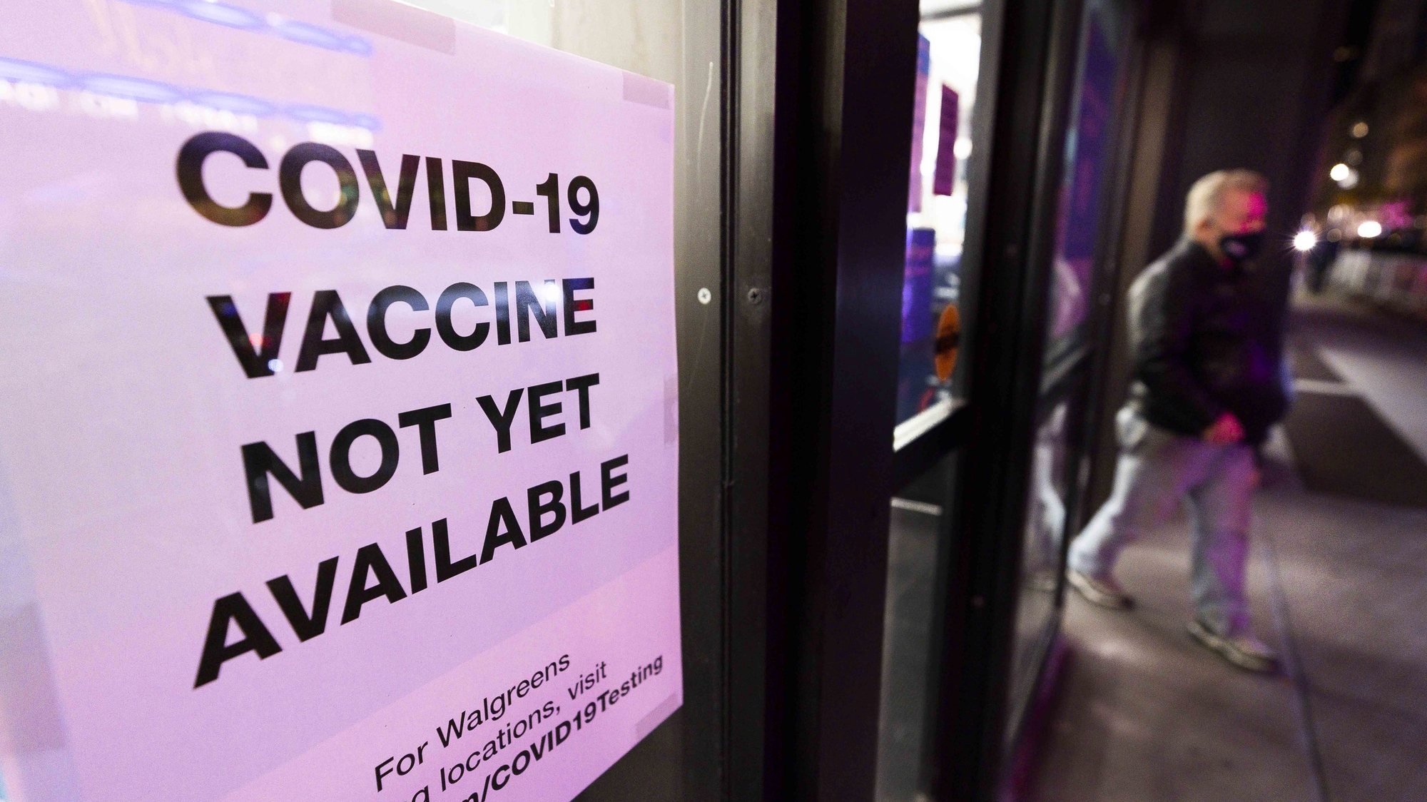 epa08856316 Sign informing customers about COVID-19 vaccine availability hangs on a window at a drug store in New York, USA, 01 December 2020.  EPA/JUSTIN LANE