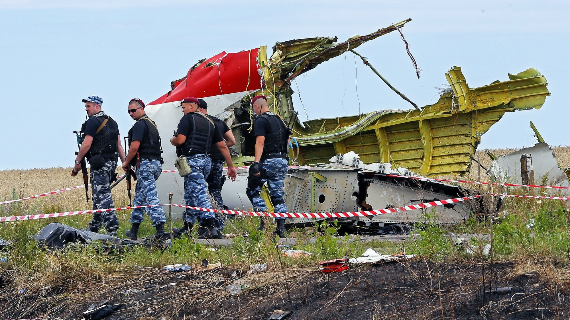 epa08255990  (FILE) - Armed rebel soldiers pass in front of a big piece of debris at the main crash site of the Boeing 777 Malaysia Airlines flight MH17, which crashed while flying over the eastern Ukraine region, near Grabovo, some 100 kilometers east from Donetsk, Ukraine, 19 July 2014. 
The District Court in The Hague on 09 March 2020 is due to start a trial against four people believed of being involved in the shooting down of a civil Boeing 777 plane over Ukraine on 17 July 2014. Dutch prosecutors charge three people with Russian citizenship and a Ukrainian national over the downing of Malaysia Airlines Flight MH17 from Amsterdam to Kuala Lumpur in which 283 passengers and 15 crew members on board were killed. Most of the victims were Dutch, Malaysian and Australian nationals. A Joint Investigation Team (JIT) from Belgium, Ukraine, Australia and Malaysia in their report came to the conclusion that a Russian-made BUK missile that hit the plane was fired from territory controlled by pro-Russian rebels. Russia has denied any responsibility for the downing and blamed Ukraine for the tragedy. It is not expected that the four accused will attend the trial as Russian law would prohibit their extradition.  EPA/ROBERT GHEMENT *** Local Caption *** 51488376
