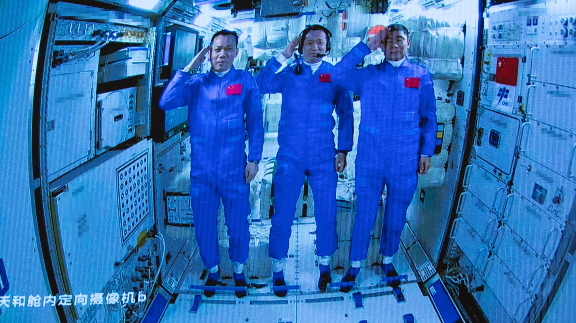 epa09281811 A screen image made available by Xinhua News Agency captured at the Beijing Aerospace Control Center shows three Chinese astronauts onboard the Shenzhou-12 spaceship saluting after entering the Tianhe space station core module in Beijing, China, 17 June 2021 (issued 18 June 2021). China launched the Shenzhou-12 spacecraft carrying three crew members Tang Hongbo, Nie Haisheng, and Liu Boming to the orbiting Tianhe core module for a three-month mission on 17 June. The mission is China&#039;s first manned spaceflight in almost five years.  EPA/XINHUA/JIN LIWANG MANDATORY CREDIT EDITORIAL USE ONLY/NO SALES
