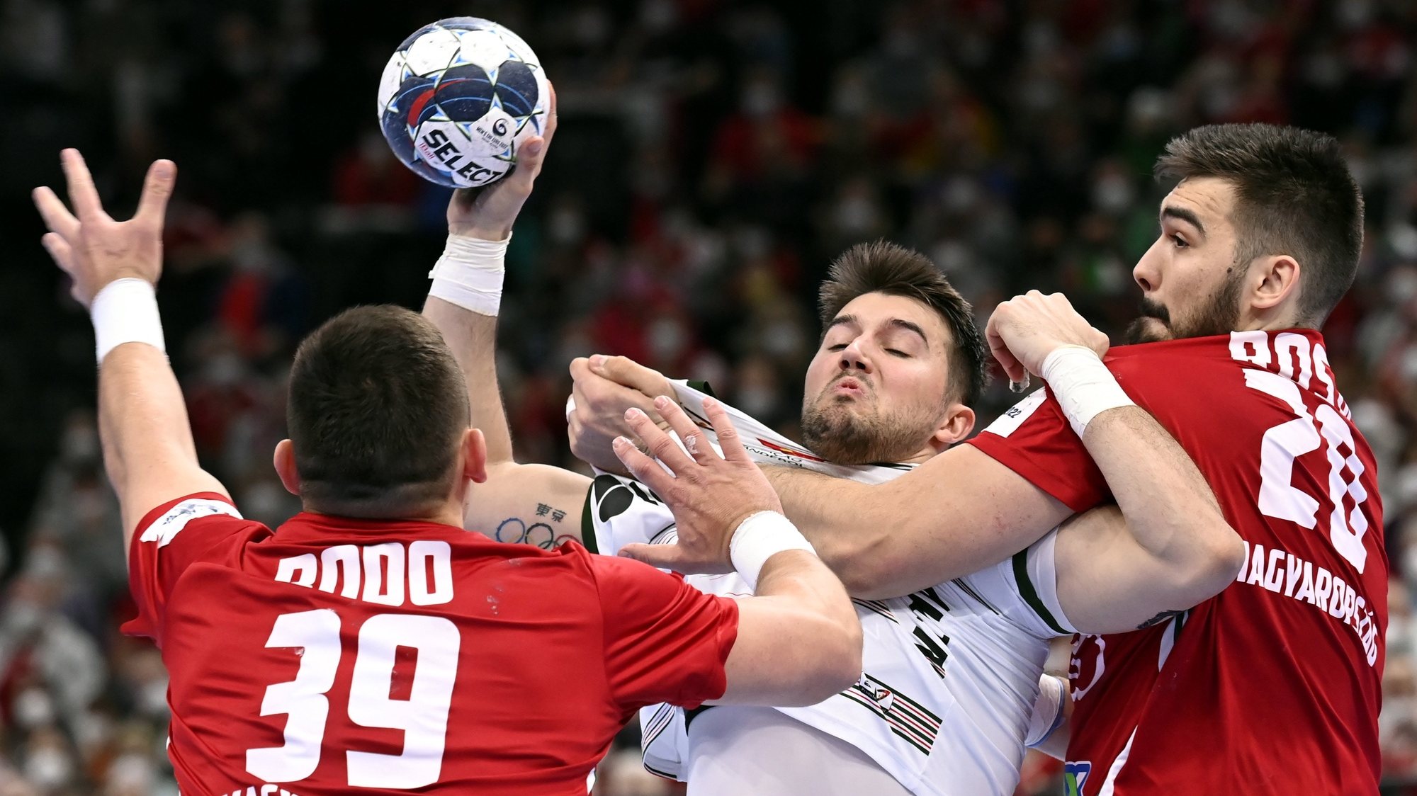 epa09689778 Miguel Martins Soares (C) of Portugal is challenged by Richard Bodo (L) and Miklos Rosta (R) of Hungary during the Mens Handball European Championship peliminary round Group B match Portugal vs. Hungary in MVM Dome in Budapest, Hungary, 16 January 2022.  EPA/Tamas Kovacs HUNGARY OUT