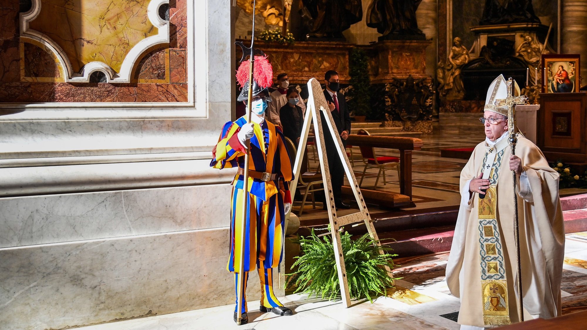 epa08835419 Pope Francis (R) walks by a Swiss Guard wearing a face mask, as he leaves after celebrating a Mass for the feast of Christ the King, as part of World Youth Day at St. Peter&#039;s Basilica in The Vatican, 22 November 2020.  EPA/VINCENZO PINTO / POOL