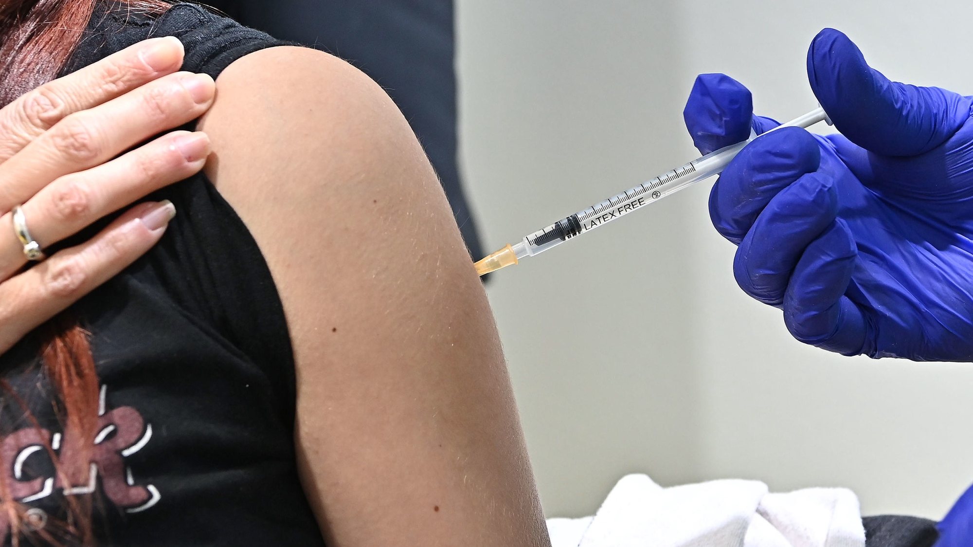 epa09073510 A woman receives a Covid-19 vaccine during the opening of a vaccination centre in a gymnasium of the university sports center in via Artom, amid the Covid-19 Coronavirus pandemic, in Turin, Italy, 14 March 2021. Most of Italy will be a COVID-19 red zone from 15 March 2021 due to a sharp rise in the number of COVID-19 cases.  EPA/Alessandro Di Marco
