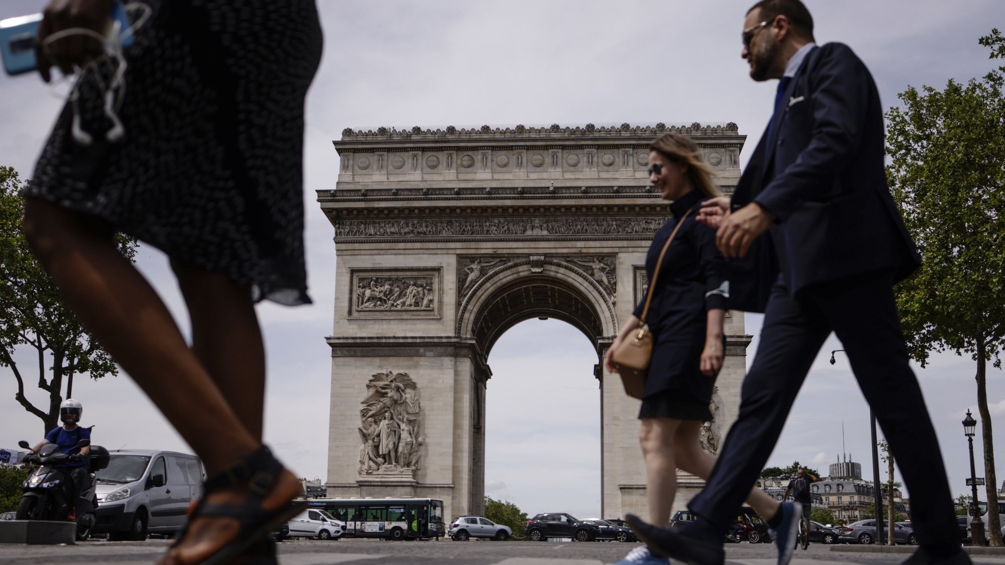 epa09279479 People not wearing protective face masks walk past the Arc of Triomphe in Paris, France, 17 June 2021. France eases some of its coronavirus disease (COVID-19) restrictions starting on 17 June, allowing not to wear a face mask in the streets.  EPA/YOAN VALAT