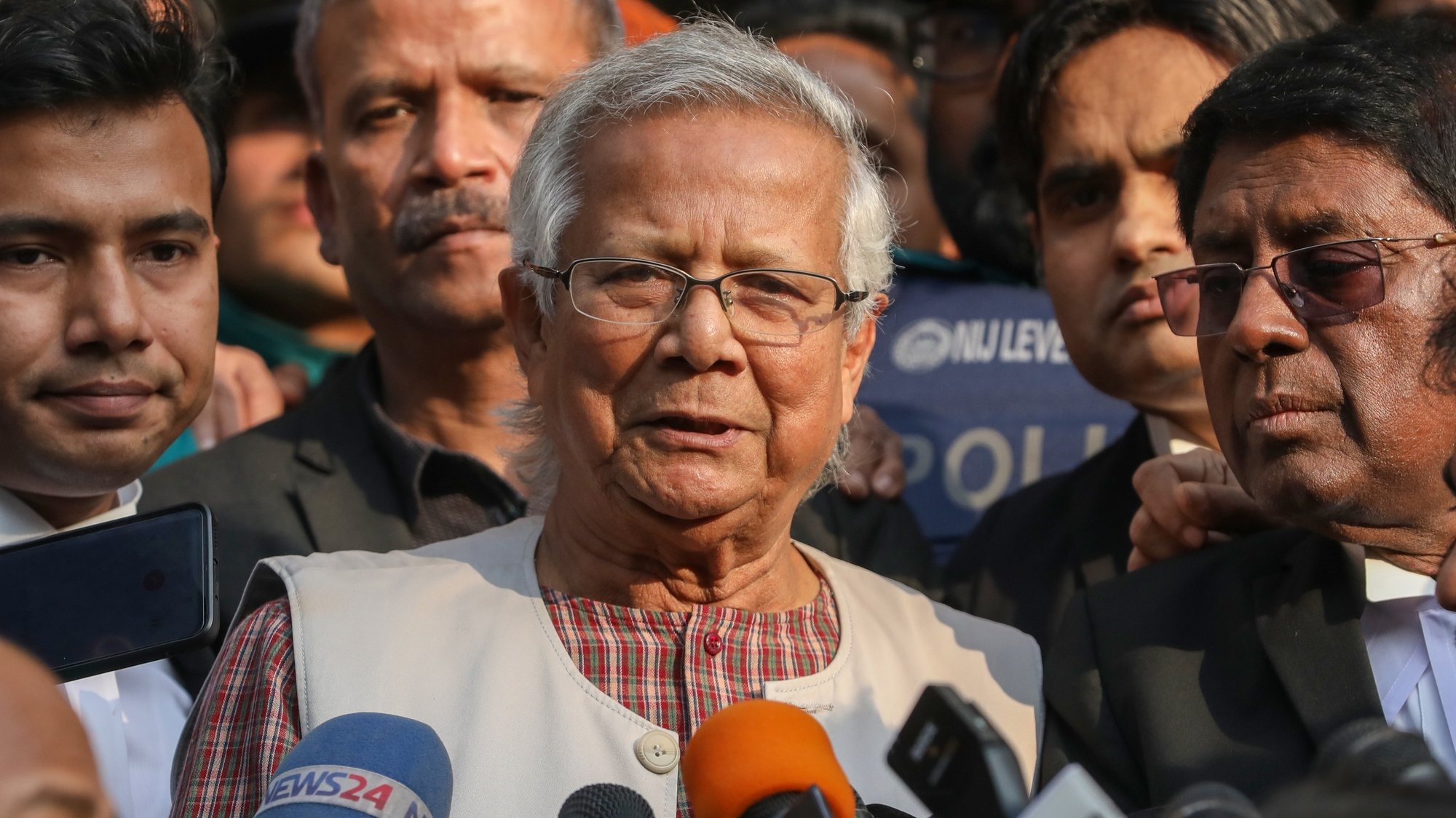 epa11052120 Bangladeshi Nobel peace laureate Muhammad Yunus (C) talks to the media outside the Dhaka Labor Court in Dhaka, Bangladesh, 01 January 2024. Yunus and three other top officials of Grameen Telecom were sentenced to six months of imprisonment in a case over labor law violations.  EPA/MONIRUL ALAM