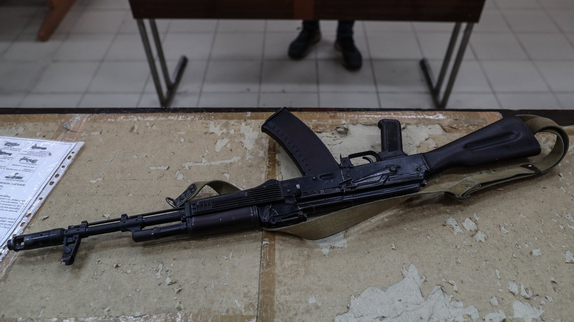 epa09840905 AK-47 rifle is seen on the table while locals of Odessa learn war tactics and how to handle weapons, in south Ukrainian city of Odesa, in Ukraine, 21 March 2022. Russian troops entered Ukraine on 24 February prompting the country&#039;s president to declare martial law and triggering a series of announcements by Western countries to impose severe economic sanctions on Russia.  EPA/SEDAT SUNA