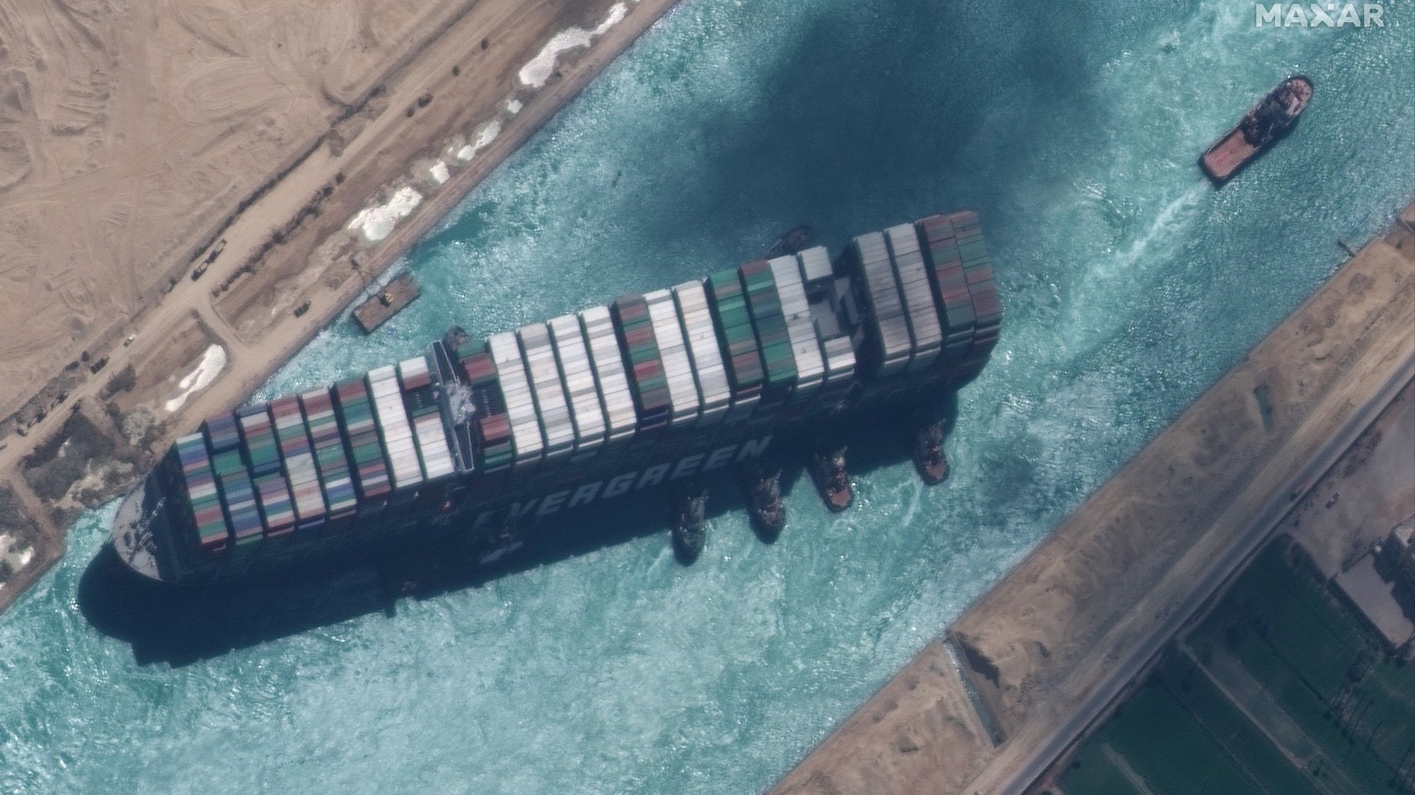 epa09105214 A handout satellite image made available by MAXAR Technologies shows , the Ever Given container ship after it has been moved away from the eastern bank of the canal and tugboats trying to reposition the ship, in the Suez Canal, Egypt, 29 March 2021. The head of the Suez Canal Authority announced on 29 March that the large container ship, which ran aground in the Suez Canal on 23 March, is now free floating after responding to the pulling maneuvers.  EPA/MAXAR TECHNOLOGIES HANDOUT MANDATORY CREDIT: SATELLITE IMAGE 2020 MAXAR TECHNOLOGIES -- the watermark may not be removed/cropped -- HANDOUT EDITORIAL USE ONLY/NO SALES HANDOUT EDITORIAL USE ONLY/NO SALES