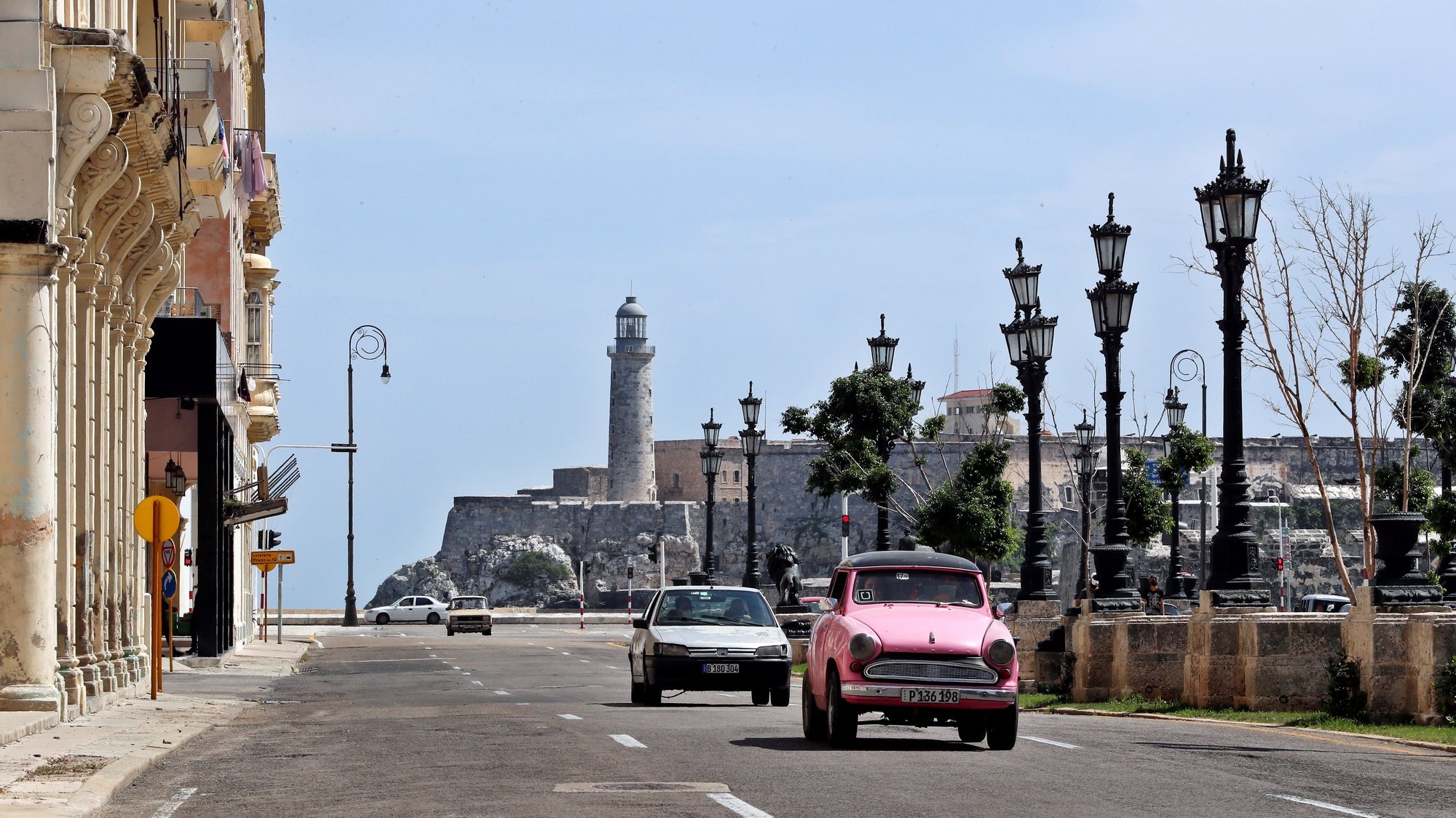 epa09340952 Several cars pass by the Paseo del Prado and next to the Castillo del Morro in Havana, Cuba, 12 July 2021. The streets of the Cuban capital remain calm one day after the large demonstrations against the government.  EPA/Ernesto Mastrascusa