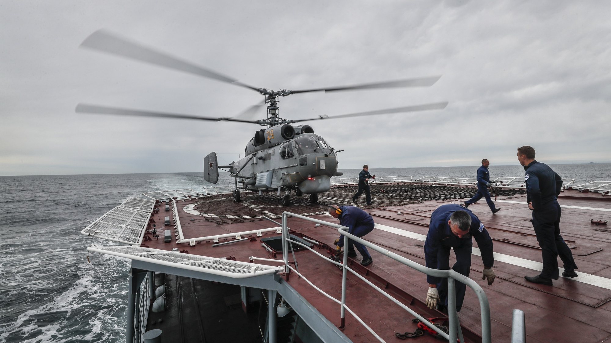 epa10161694 Russian Navy sailors prepare a helicopter for take off on the large anti-submarine ship Marshal Shaposhnikov during the Vostok 2022 strategic command and staff exercise in the Peter the Great Gulf of the Sea of Japan, near Vladivostok, Russia, 05 September 2022. The Vostok 2022 strategic command and staff exercise will take place from 01 to 07 September 2022 and will involve over 50,000 servicemen and more than 5,000 units of weapons and military equipment.  EPA/YURI KOCHETKOV