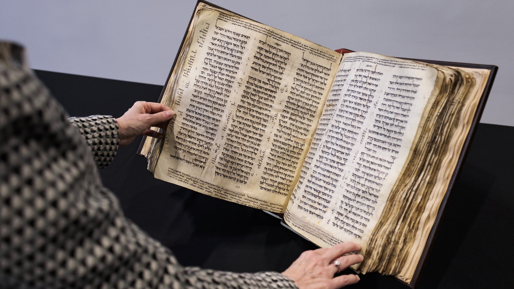 epa10468746 Sharon Mintz, Sotheby’s Senior Specialist for Judaica, with the Codex Sassoon, the earliest and most complete known Hebrew Bible, during an auction preview for the centuries-old manuscript at Sotheby’s in New York, New York, USA, 15 February 2023. The bound, parchment text, which was once owned by David Solomon Sassoon and dates from the late ninth to early tenth century, is expected to sell for USD 30 to 50 million ( 28 to 46 million Euro) when is goes up for auction later this year.  EPA/JUSTIN LANE