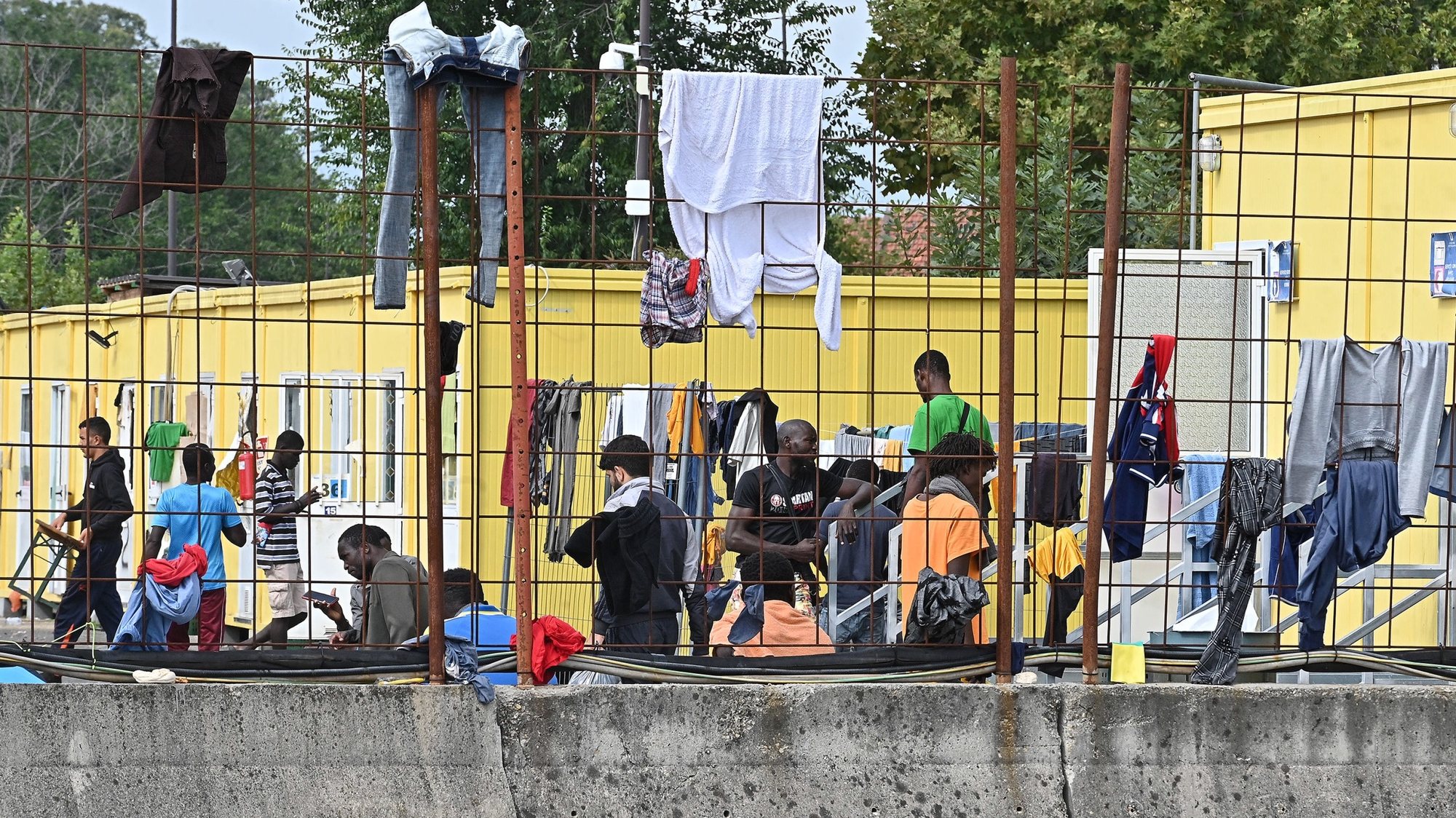 epa10871645 Migrant dry their clothes on a fence at the Red Cross reception centre in Via Tres, Turin, Italy, 20 September 2023. The center houses some 500 people in a compound and facilities which are meant for between 140 and 180 people in need. Italy saw an influx of thousands of migrants in the past weeks. According to Italy&#039;s Interior Ministry, nearly 126,000 immigrants and refugees have entered the country as of 2023, more than twice as many as during the same time period in 2022.  EPA/ALESSANDRO DI MARCO