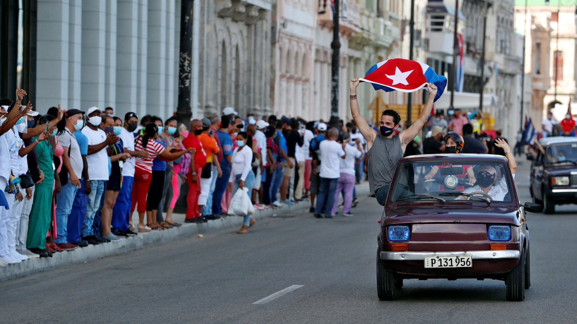 epa09398551 A person waves a Cuban flag during a march in support of the Cuban revolution through the Malecon area in Havana, Cuba, 05 August 2021. Cubans took to the streets in Cuba on 11 July to protest the government response to the COVID-19 pandemic, shortages of medicines and basic commodities, and decliing infrustructure on the island nation.  EPA/Ernesto Mastrascusa