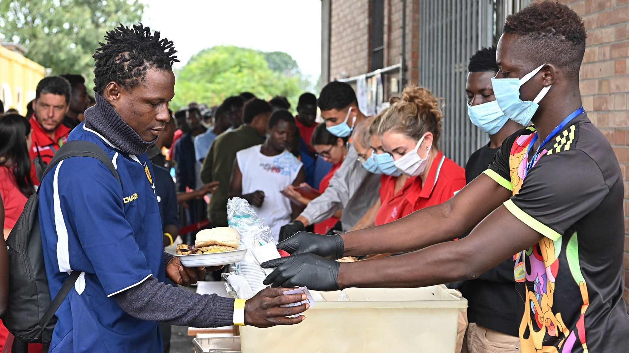 epa10871656 Migrants qreceive free meals at the food distribution point of the Red Cross reception centre in Via Tres, Turin, Italy, 20 September 2023. The center houses some 500 people in a compound and facilities which are meant for between 140 and 180 people in need. Italy saw an influx of thousands of migrants in the past weeks. According to Italy&#039;s Interior Ministry, nearly 126,000 immigrants and refugees have entered the country as of 2023, more than twice as many as during the same time period in 2022.  EPA/ALESSANDRO DI MARCO