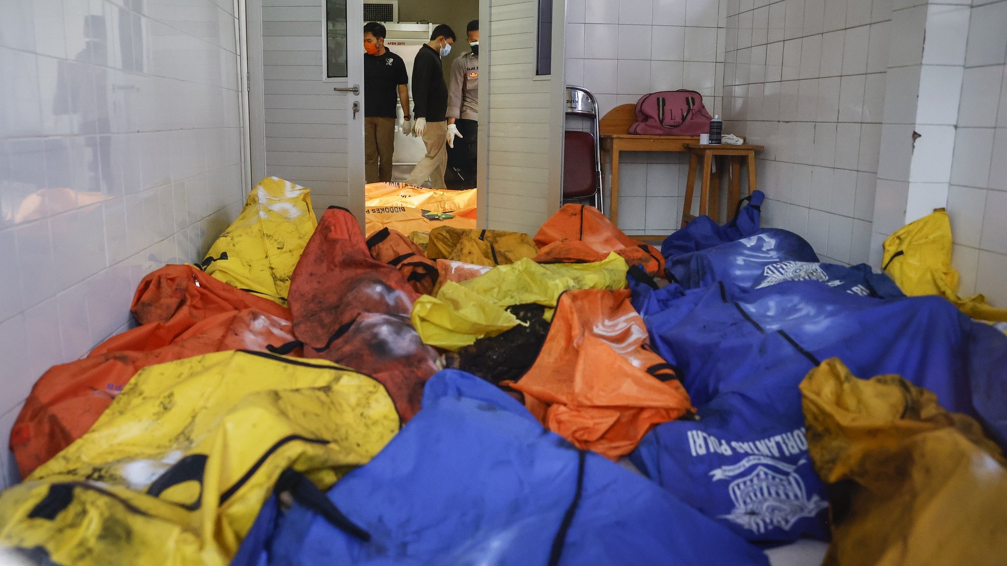 epa09454476 Disaster Victims Identification (DVI) police officers inspect body bags in the aftermath of a prison fire, at a hospital in Tangerang, Banten, Indonesia, 08 September 2021. A fire broke out in a prison in Tangerang killing at least 41 people and injuring dozens.  EPA/MAST IRHAM