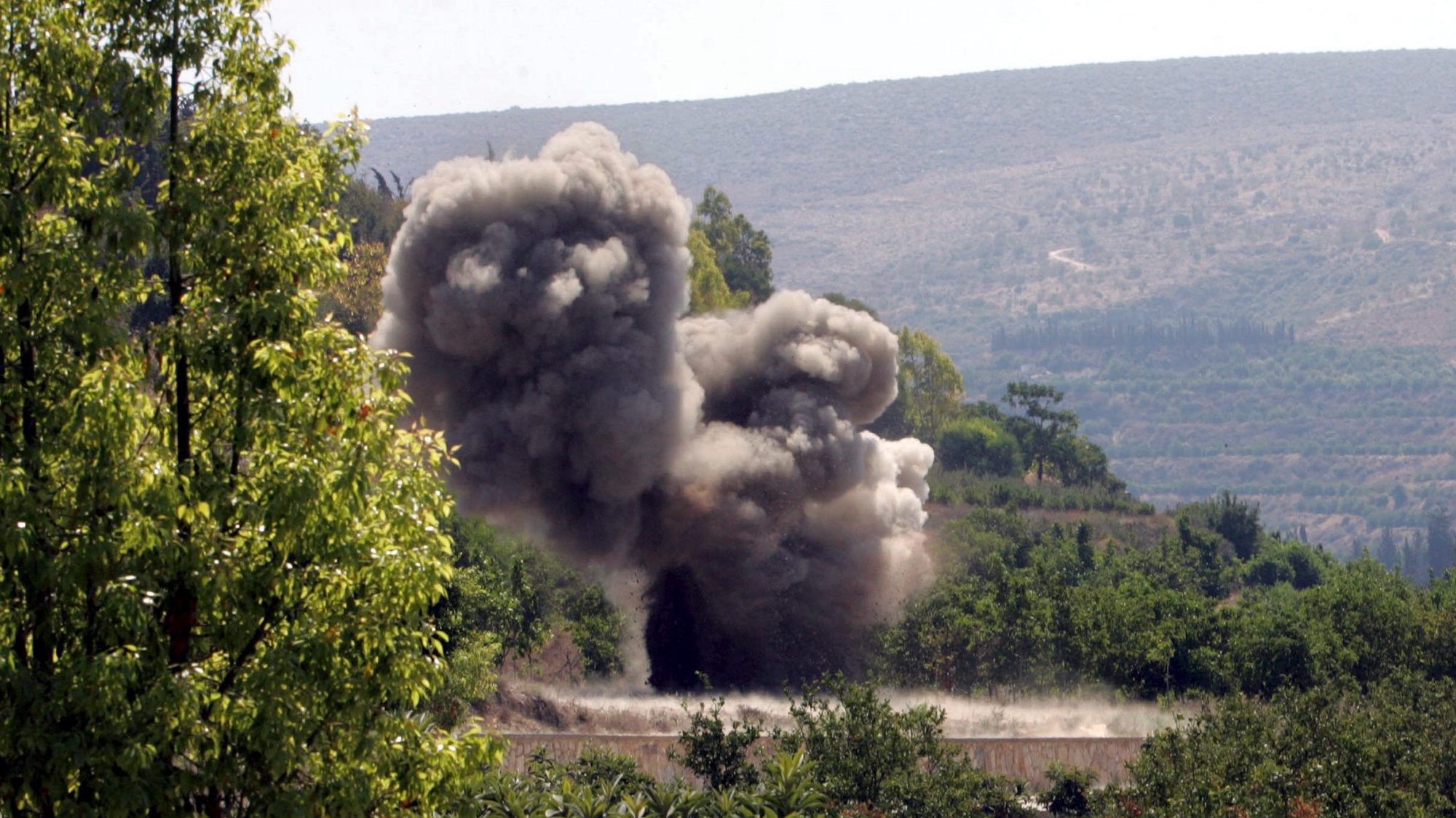 epa00809676 An explosion of bomblets detonated by the Chinese U.N experts, after they were collect from cluster bombs dropped by Israeli forces during the recent conflict with Hezbollah, found on a fruit farm near the village of Al Hinneyeh in southern Lebanon Tuesday 05 September, 2006. The bomblets were later safely detonated.  EPA/MOHAMED MESSARA