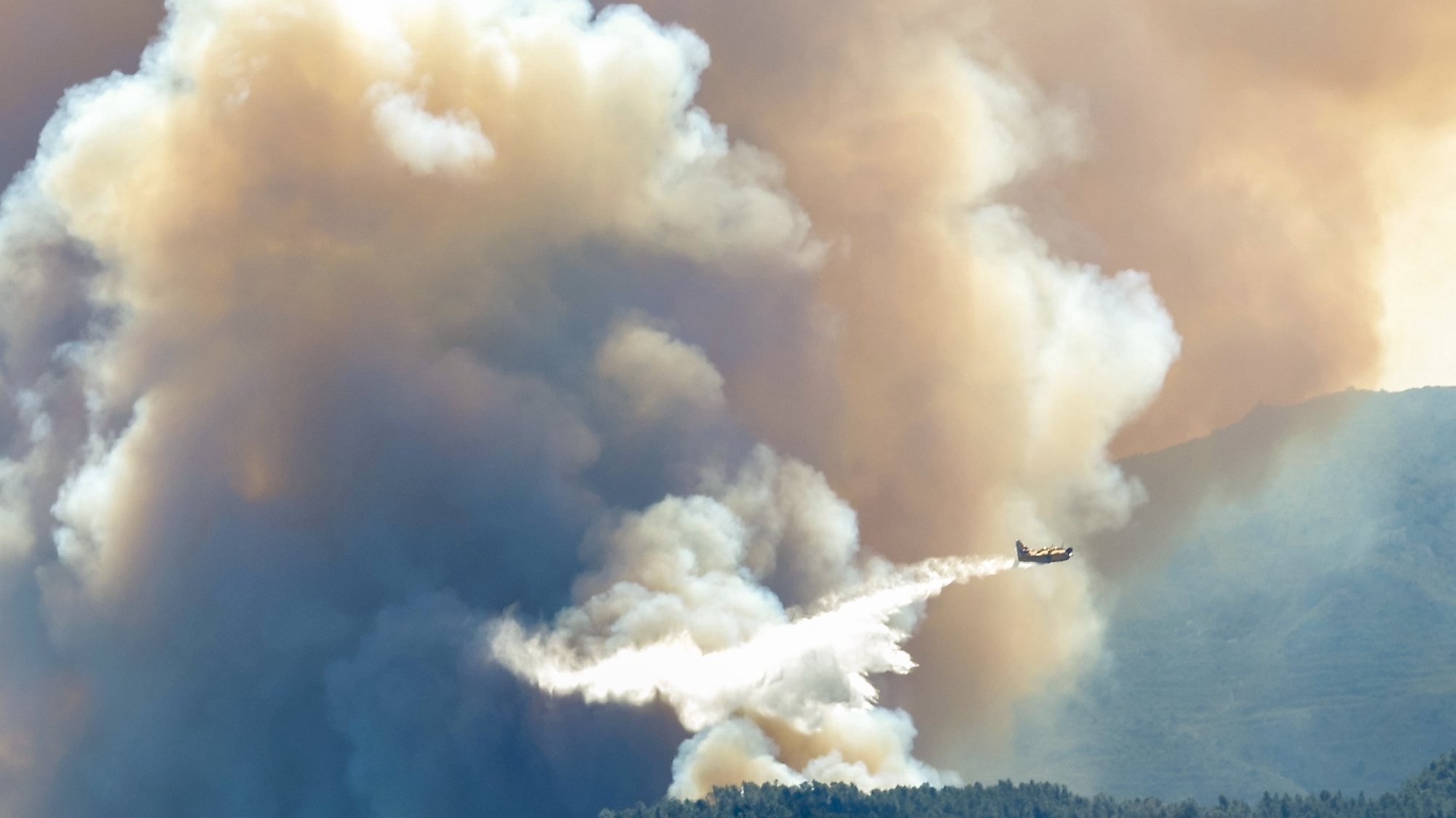 epa10545251 A plane drops extinguishing agent on a wildfire at Villanuena de Viver village, Castellon, Spain, 27 March 2023. The fire has consumed some 4,000 hetares so far.  EPA/Domenech Castello
