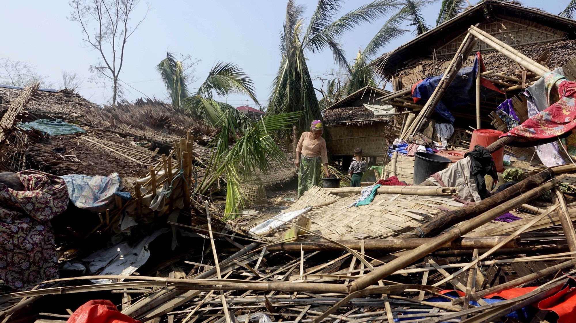 epa10633756 A Rohingya woman stands near a damaged house at the Thae Chaung Muslim internally displaced people (IDPs) camp near Sittwe, Rakhine State, Myanmar, 17 May 2023. On 14 May tropical cyclone &#039;Mocha&#039; hit the coastal regions of Myanmar and Bangladesh with maximum sustained winds of 250 kph, wreaking havoc on thousands of vulnerable communities. According to the Global Disaster Alert and Coordination System (GDACS), around three million people in Myanmar and Bangladesh were affected by the strong winds. The world&#039;s largest refugee camp in Cox&#039;s Bazar in southern Bangladesh and Rakhine State in western Myanmar were on the cyclone&#039;s route. The UN humanitarian aid office OCHA warned that torrential rains and heavy floods in cyclone-hit areas have also increased the risk of landslides ahead of the monsoon season.  EPA/STRINGER