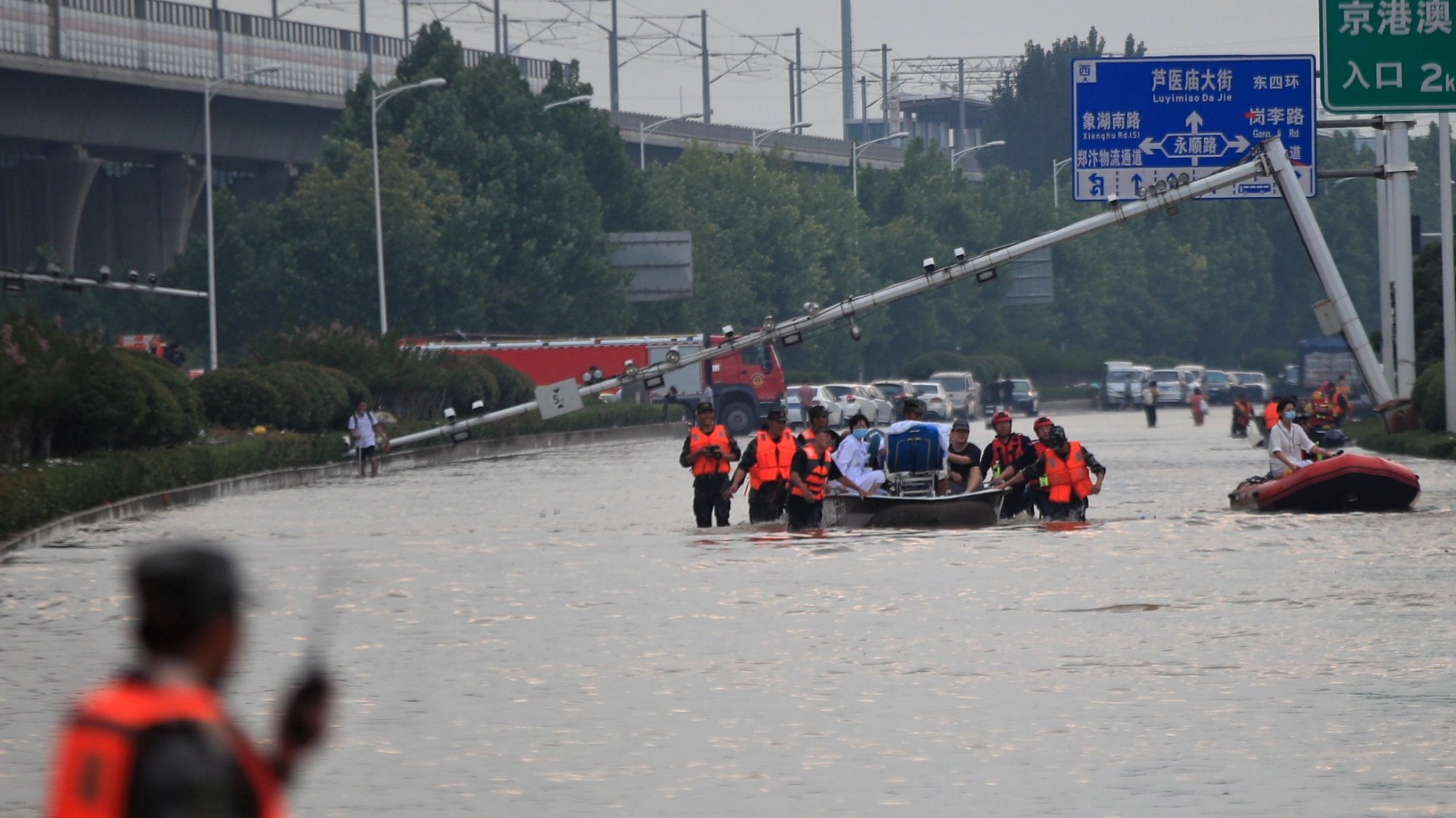 epa09358199 Rescuers evacuate people from a hospital where about 3,000 people were trapped by the flood in Zhengzhou, central China&#039;s Henan province, 22 July 2021. Thirty-three people were found dead in the flooding, and eight more are missing.  EPA/STRINGER CHINA OUT