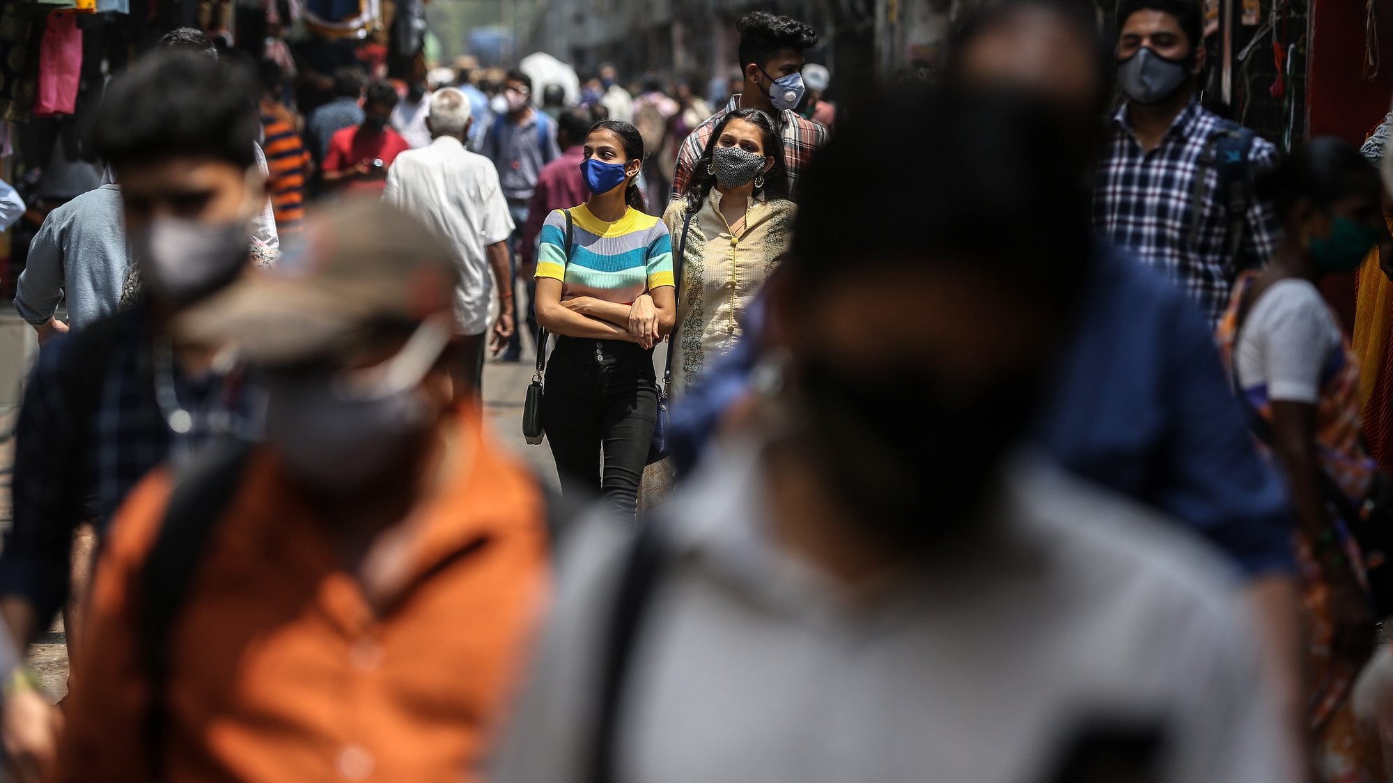 epa09090160 People wearing face masks walk in the streets of Mumbai, India, 22 March 2021. Maharashtra is the worst-hit state and it reported 30,535 fresh COVID-19 positive cases, the highest rise in a single day.  EPA/DIVYAKANT SOLANKI