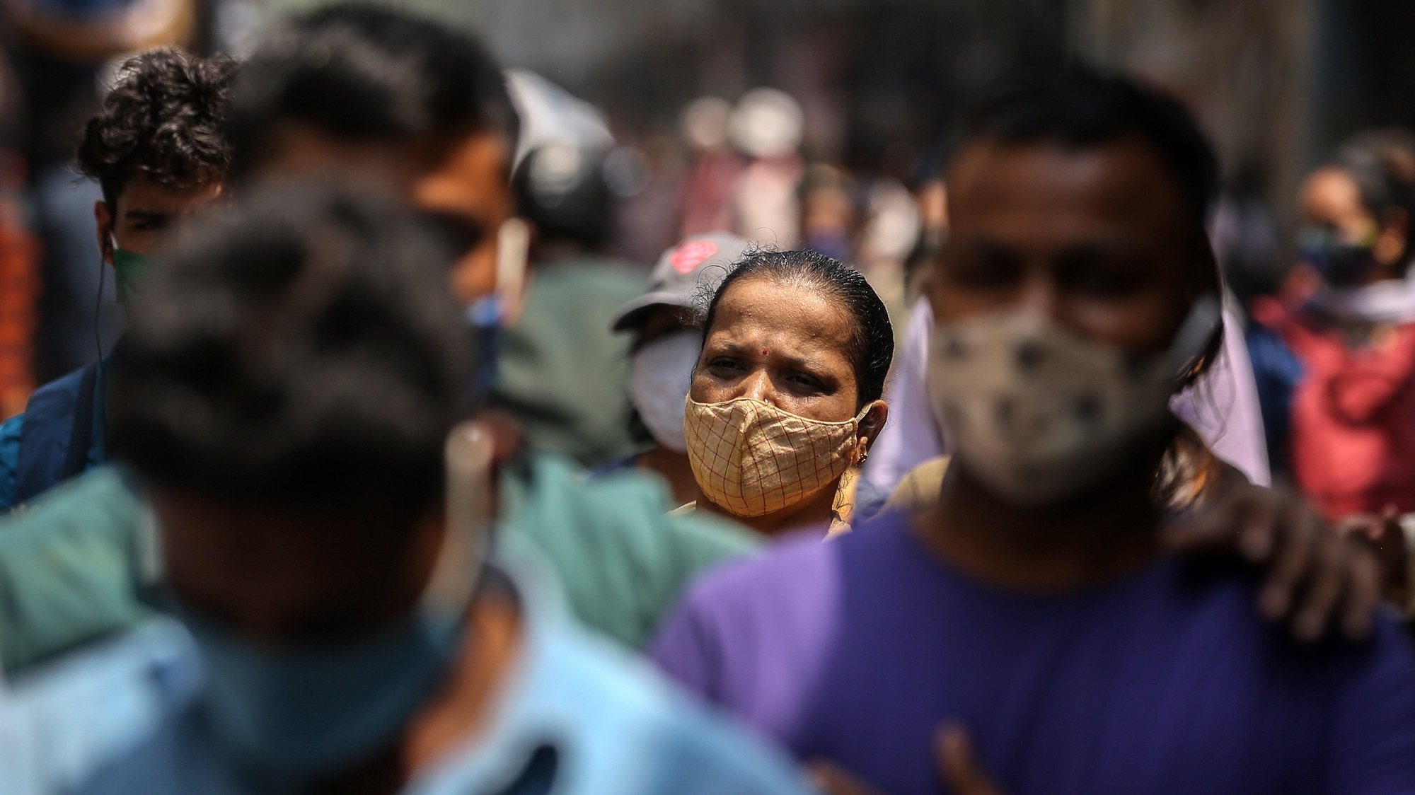 epa09090156 People wearing face masks walk in the streets of Mumbai, India, 22 March 2021. Maharashtra is the worst-hit state and it reported 30,535 fresh COVID-19 positive cases, the highest rise in a single day.  EPA/DIVYAKANT SOLANKI