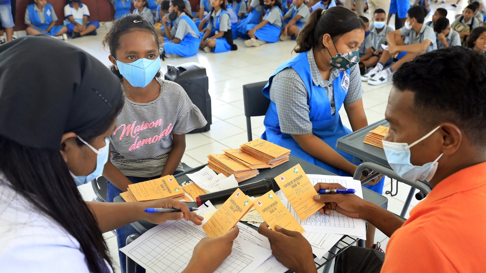epa09612060 Students register for a Pfizer COVID-19 vaccine injection during a vaccination drive for children over twelve years of age in Dili, East Timor, also known as Timor Leste, 30 November 2021. East Timor has recorded more than 19,800 coronavirus disease (COVID-19) cases since the beginning of the pandemic.  EPA/ANTONIO DASIPARU