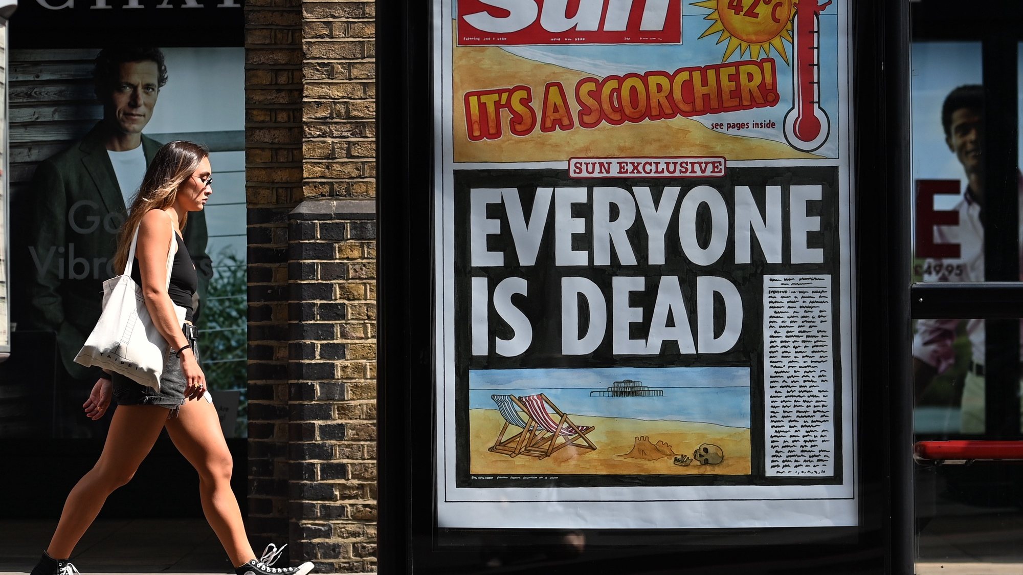epa10082068 A pedestrian walks past a newspaper headline highlighting the extreme heat in London, Britain, 20 July 2022. The UK has seen temperatures reach over 40C during the heatwave that has spread from southern Europe.  EPA/ANDY RAIN