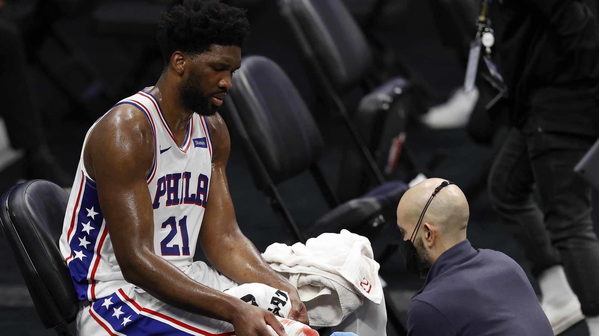 epa09000228 A trainer tends to Philadelphia 76ers center Joel Embiid (L) after a play against the Sacramento Kings during the second half of the NBA basketball game between the Philadelphia 76ers and Sacramento Kings at Golden 1 Center in Sacramento, California, USA, 09 February 2021.  EPA/JOHN G. MABANGLO SHUTTERSTOCK OUT