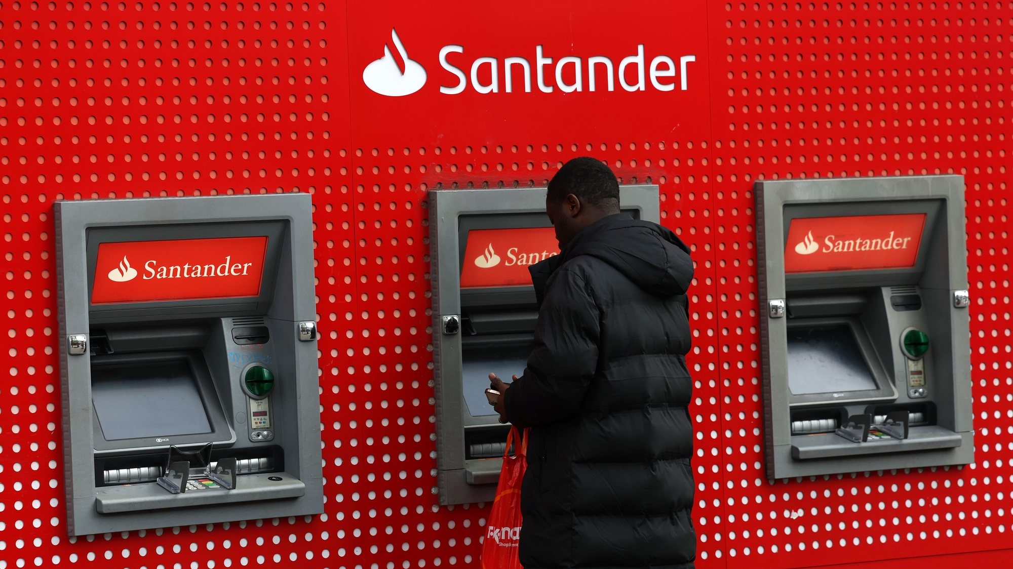epa10938122 A customer uses a Santander ATM machine at a Santander bank branch in London, Britain, 25 October 2023. Santander has announced soaring third quarter profits at 2.9 billion euros, rising by some twenty percent from the same time last year.  EPA/ANDY RAIN