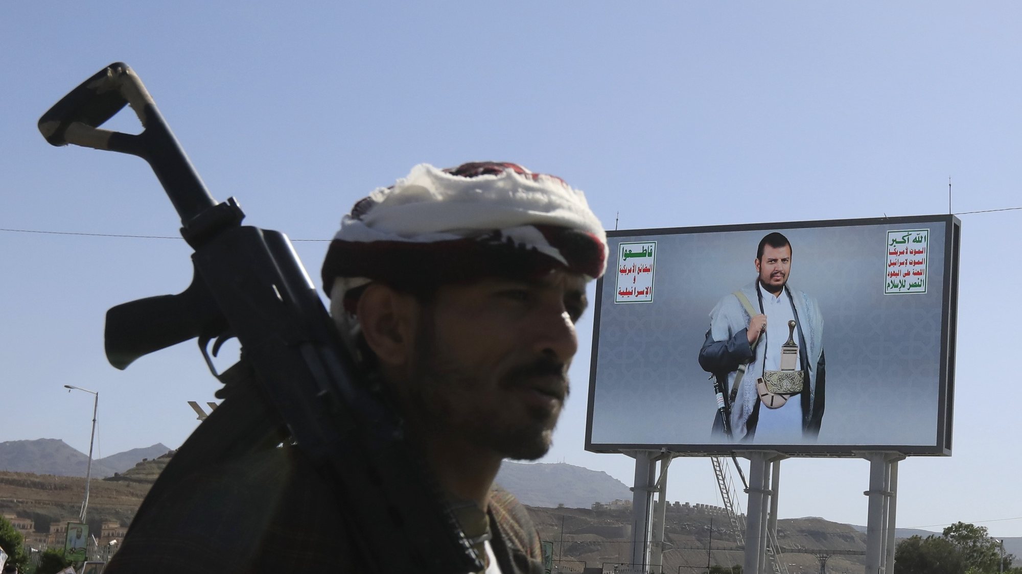 epa11396131 An armed Houthi supporter passes a billboard featuring Houthis&#039; leader Abdul-Malik al-Houthi, during a protest against the US and Israel, and in solidarity with the Palestinian people, in Sana&#039;a, Yemen, 07 June 2024. Thousands of Houthi supporters participated in a protest in support of the Palestinian people and condemning the US support of Israeli actions in Gaza. The protest came a day after Yemen&#039;s Houthis claimed to have launched two joint drone attacks with an Iraqi militia group against ships at Israel&#039;s Haifa port, in retaliation for the Israeli military operations in Gaza, vowing to keep up maritime attacks in solidarity with Palestinians, according to a statement by Houthi military spokesman Yahya Sarea.  EPA/YAHYA ARHAB