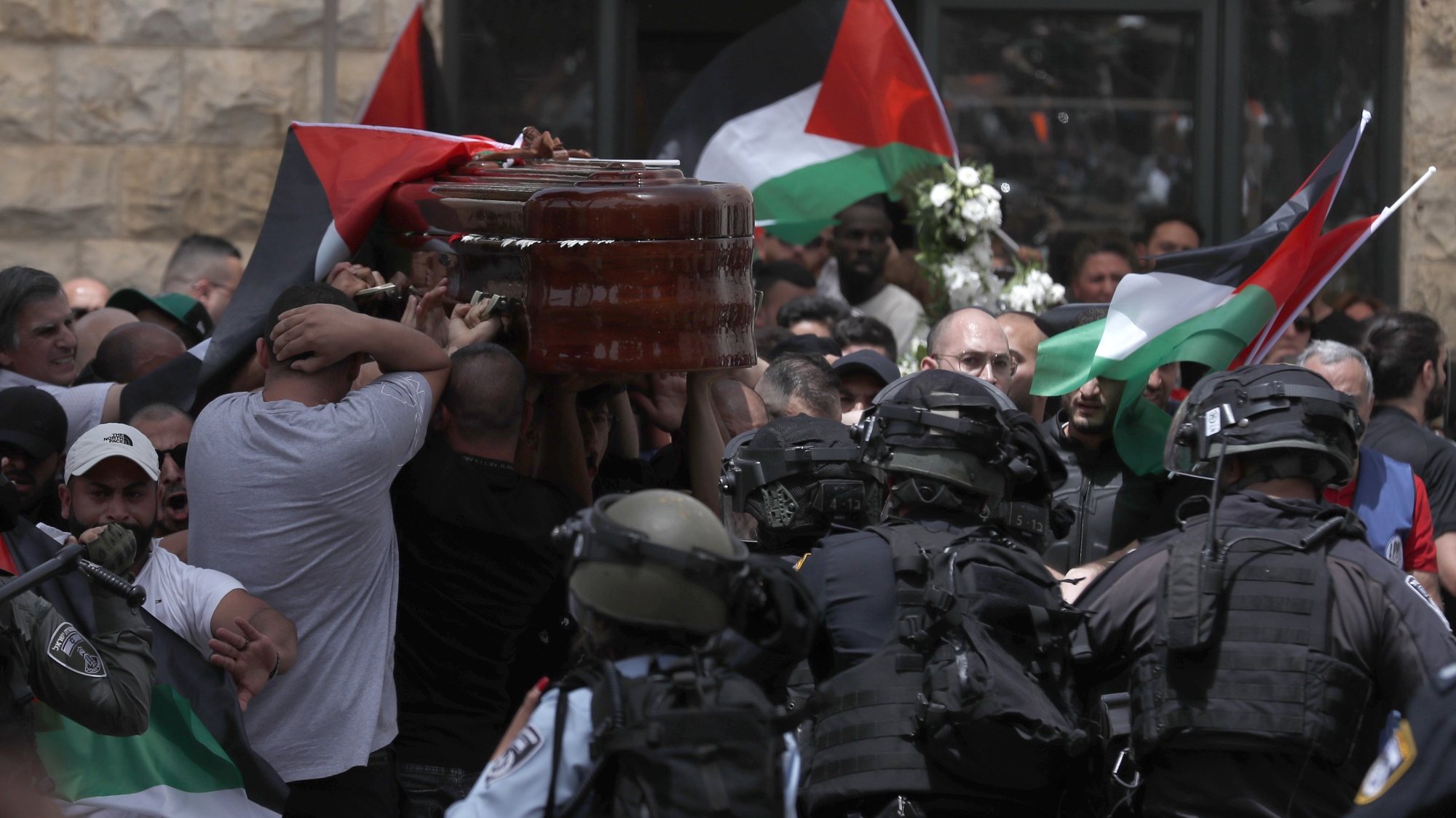 epa09944328 Mourners carry the coffin of slain American-Palestinian journalist Shireen Abu Akleh outside St. Joseph Hospital, ahead of a funeral procession in the Old City of Jerusalem, 13 May 2022. Al Jazeera journalist Shireen Abu Akleh was killed on 11 May 2022 during a raid by Israeli forces in the West Bank town of Jenin.  EPA/ATEF SAFADI