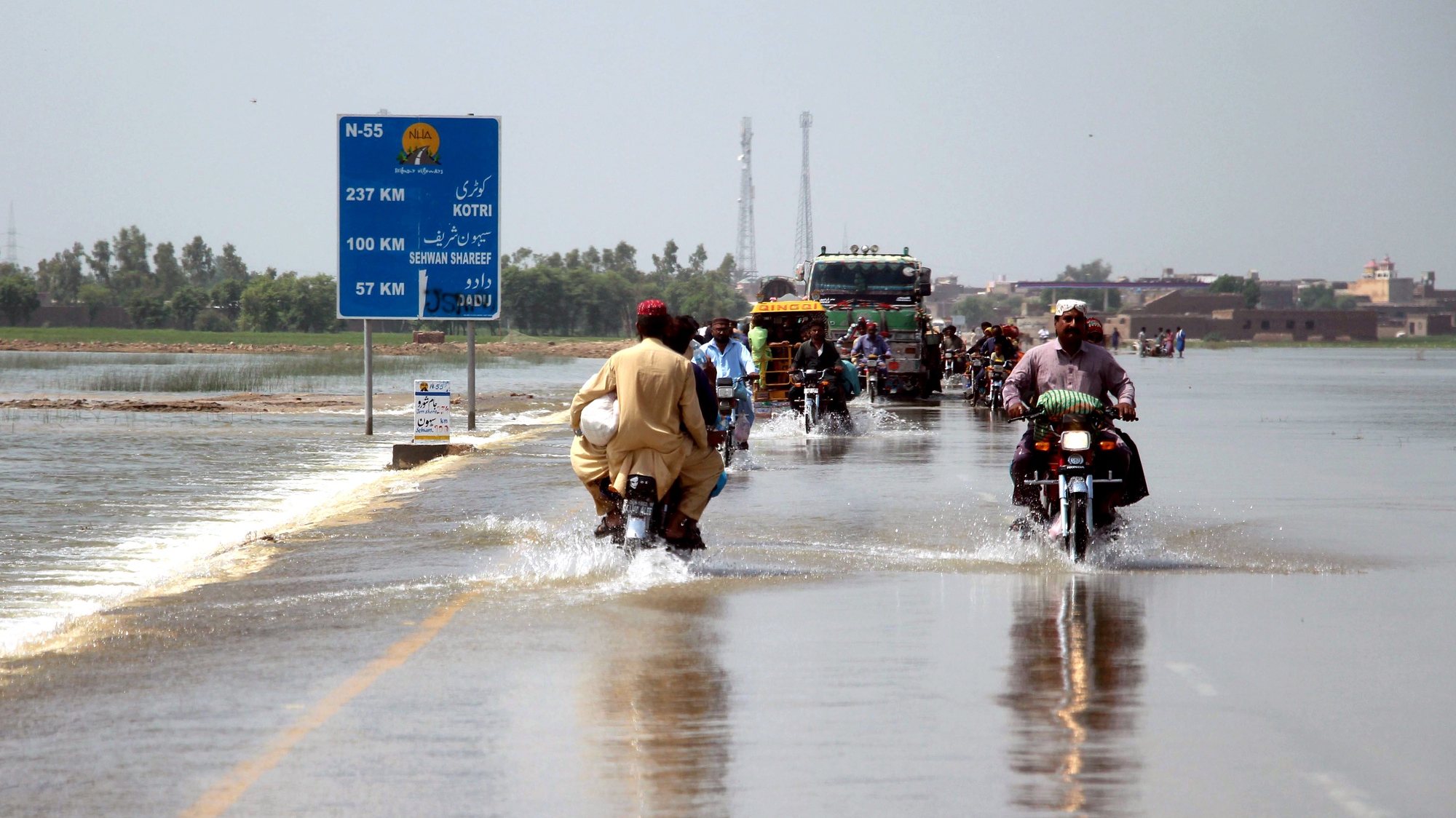 epa10147386 People cross a flooded highway in Dadu district, Sindh province, Pakistan, 30 August 2022. According to the National Disaster Management Authority (NDMA) on 27 August, flash floods triggered by heavy monsoon rains have killed over 1,000 people across Pakistan since mid-June 2022. More than 33 million people have been affected by floods, the country&#039;s climate change minister said.  EPA/WAQAR HUSSEIN