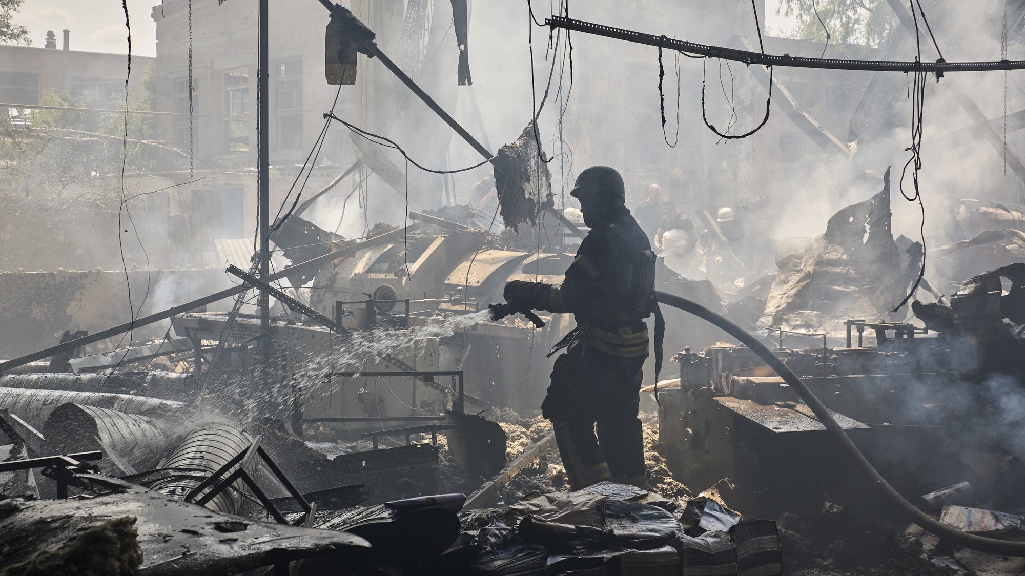 epa11363337 Ukrainian rescuers work at the site of a shelling on a printing house in Kharkiv, Ukraine, 23 May 2024, amid the Russian invasion. At least seven people were killed and 16 others were wounded in the rocket attack, according to the report of the head of the Kharkiv Military Administration Oleg Synegubov.  EPA/SERGEY KOZLOV
