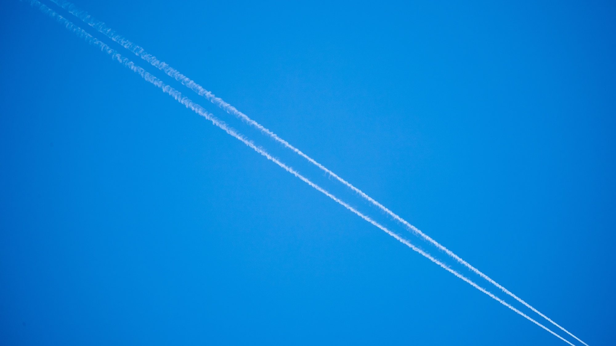 epa09789324 A plane leaves vapor trails in the blue sky as it flies over Frankfurt, Germany, 27 February 2022 (illustration with unidentified plane). Germany, along with other European states, imposed an airspace ban for Russian aircrafts with effect from 27 February 2022 as part of immediate sanctions against Russia following the invasion of Ukraine on 24 February.  EPA/CONSTANTN ZINN
