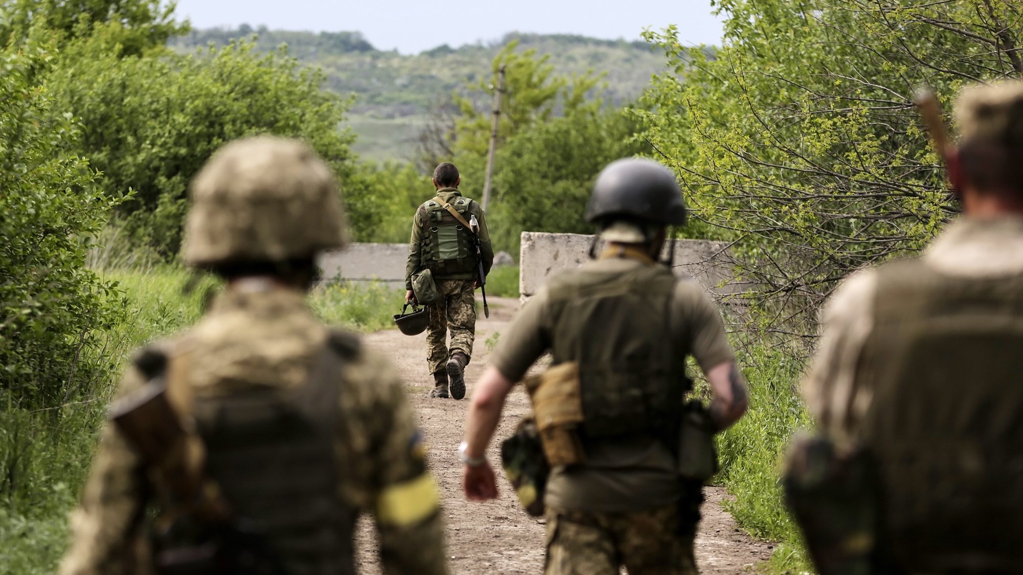 epa09985030 Ukrainian servicemen walk to their positions near the Zaytseve village of the Donetsk region, Ukraine, 29 May 2022. On 24 February, Russian troops invaded Ukrainian territory starting a conflict that has provoked destruction and a humanitarian crisis. According to the UNHCR, more than 6.5 million refugees are estimated to have fled Ukraine, and a further seven million people estimated to have been displaced internally within Ukraine since.  EPA/STR