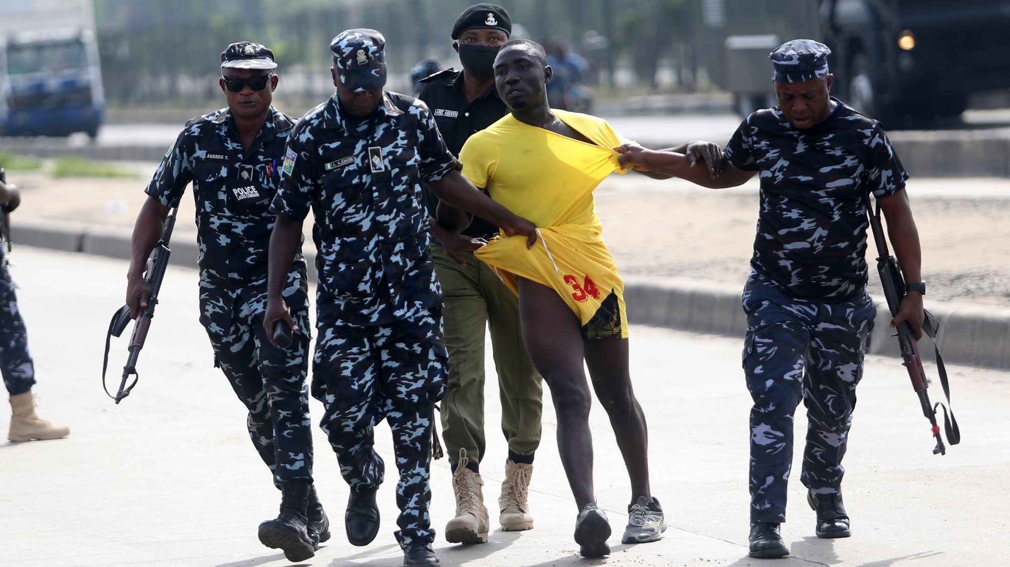 epa09264364 Policemen arrest a protester during a civil protest in the Ojota district of Lagos, Nigeria, 12 June 2021. Security operatives including the police and army personnel fired several shots of live ammunition and tear gas canisters into the air in a bid to disperse protesters demanding justice and end to bad governance in Nigeria. Activists called for protests on Democracy Day, which commemorates countryâ€™s move from military to elected civilian government in 1999.  EPA/AKINTUNDE AKINLEYE