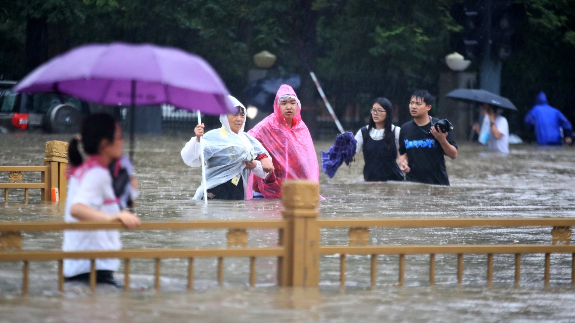 epa09356178 People walk in the flooded road after record downpours in Zhengzhou city in central China&#039;s Henan province Tuesday, July 20, 2021 (issued 21 July 2021). Heavy floods in Central China killed 12 in Zhengzhou city due to the rainfall yesterday, 20 July 2021, according to official Chinese media. Over 144,660 people have been affected by heavy rains in Henan Province since July 16, and over 10,000 had to be relocated, the provincial flood control and drought relief headquarters said Tuesday.  EPA/FEATURECHINA CHINA OUT