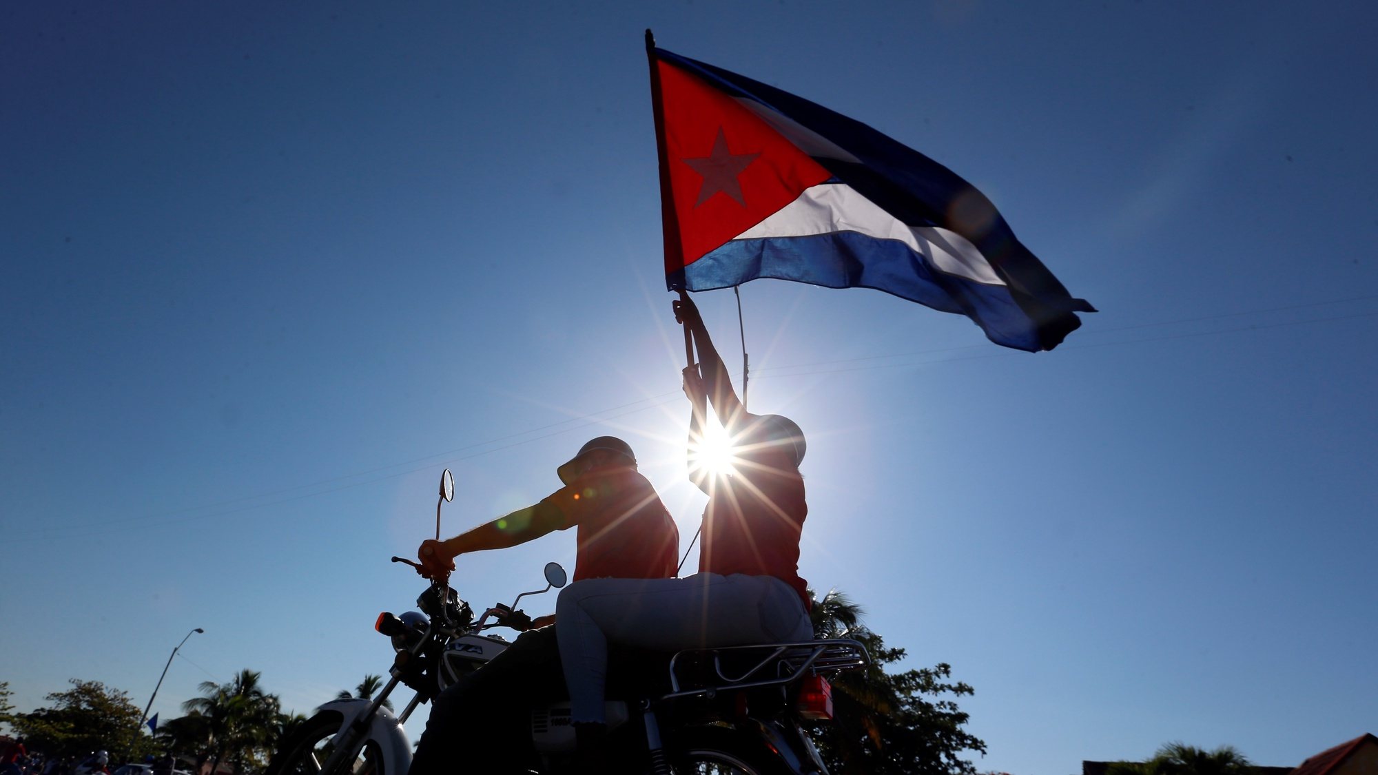epaselect epa09238177 Bikers arrive to attend a nautical regatta in Cienfuegos, Cuba, 30 May 2021. Citizens and representatives of the Union of Young Communists of Cuba (UJC) demanded the lifting of the United States embargo with a regatta in the Bay of Cienfuegos, 230 kilometers east of Havana, where a similar event took place in April.  EPA/Ernesto Mastrascusa