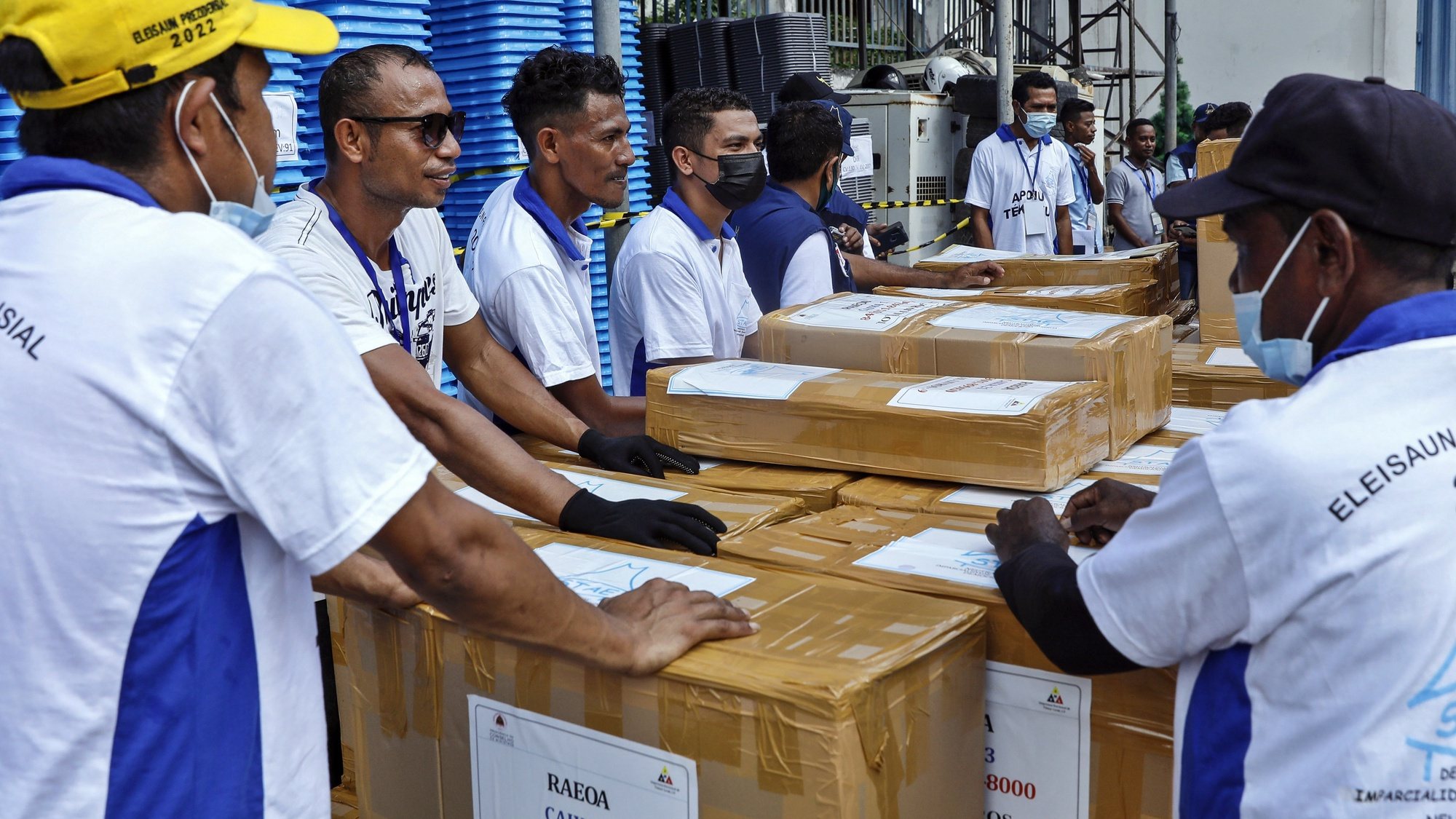 epa09816596 Workers stand next to boxes of election logistics to be transported to the various districts, in Dili, East Timor, also known as Timor Leste, 11 March 2022. The country will hold its presidential election on 19 March 2022.  EPA/ANTONIO DASIPARU