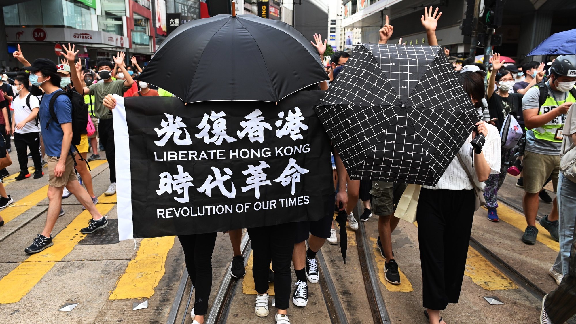epa08519966 Protesters holding umbrellas and a banner that says &#039;Liberate Hong Kong, revolution of our times&#039; march during a rally against a new national security law on the 23rd anniversary of the establishment of the Hong Kong Special Administrative Region in Hong Kong, China, 01 July 2020. Chinese President Xi Jinping has signed into law the national security legislation Beijing has tailor-made for Hong Kong, prohibiting acts of secession, subversion, terrorism and collusion with foreign forces to endanger national security.  EPA/MIGUEL CANDELA