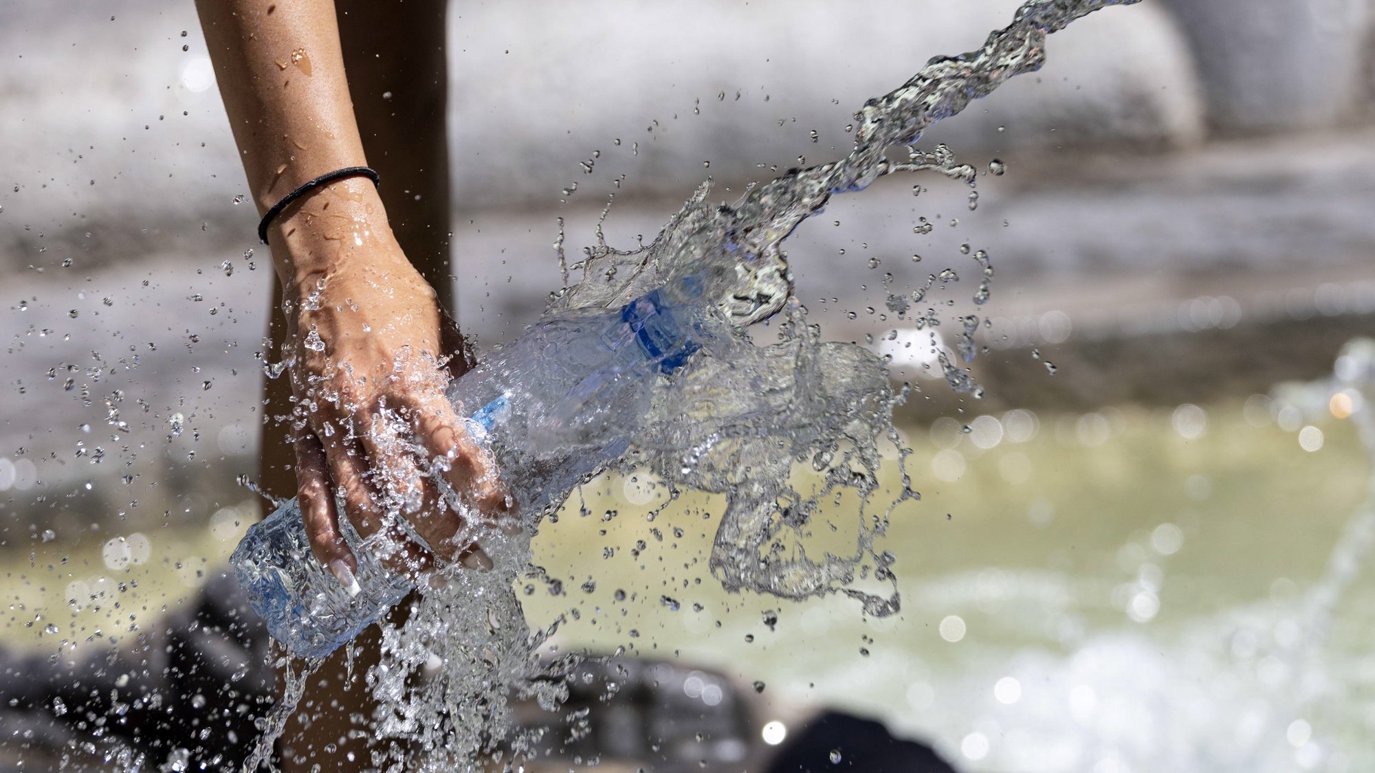 epa10047660 A person fills a bottle of water from the Barcaccia Fountain in Piazza di Spagna during a hot day in Rome, Italy, 02 July 2022. Italian health ministry said 22 cities were on red alert on 02 July over the current heat wave in Italy.  EPA/MASSIMO PERCOSSI