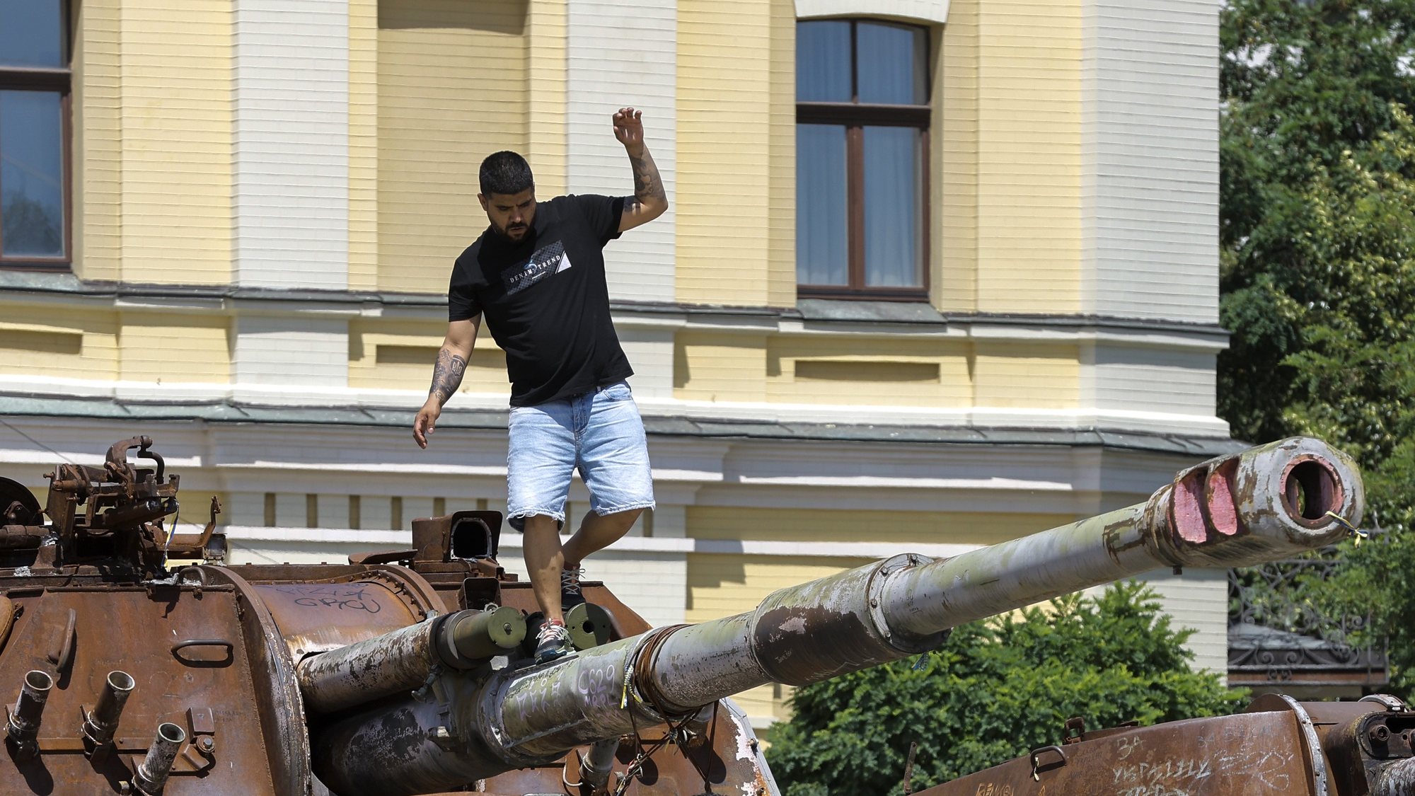 epa11443126 A man climbs on top of a destroyed Russian military machine on display near the St. Mykhailivsky Cathedral in downtown Kyiv, Ukraine, 28 June 2024, amid the Russian invasion. Russian troops entered Ukrainian territory on 24 February 2022, starting a conflict that has provoked destruction and a humanitarian crisis.  EPA/SERGEY DOLZHENKO