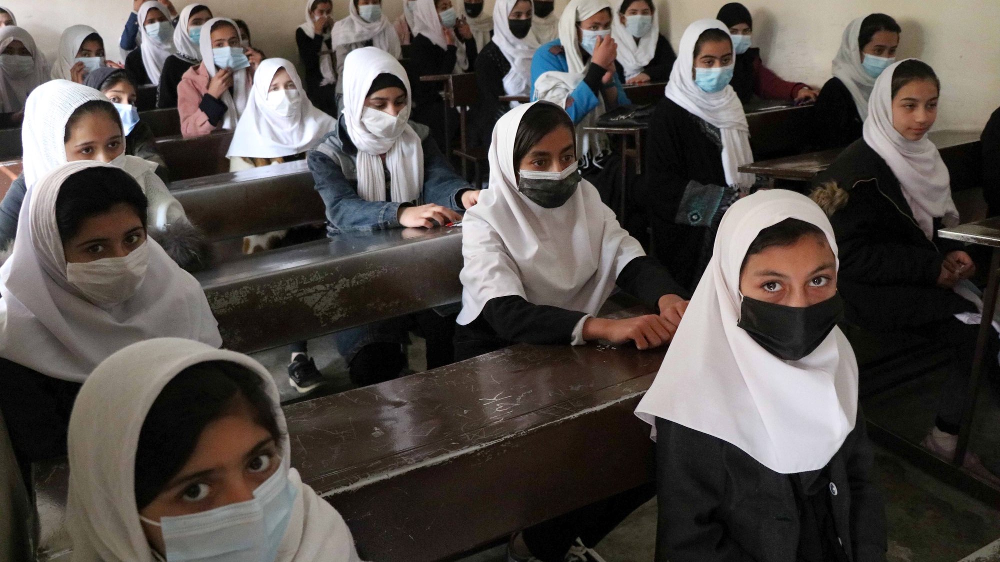 epa09056285 Afghan student girls wearing face masks attend lectures on the school in Herat, Afghanistan, 06 March 2021. Countries around the world are fighting with the second wave of the SARS-CoV-2 coronavirus which causes the COVID-19 disease.  EPA/JALIL REZAYEE