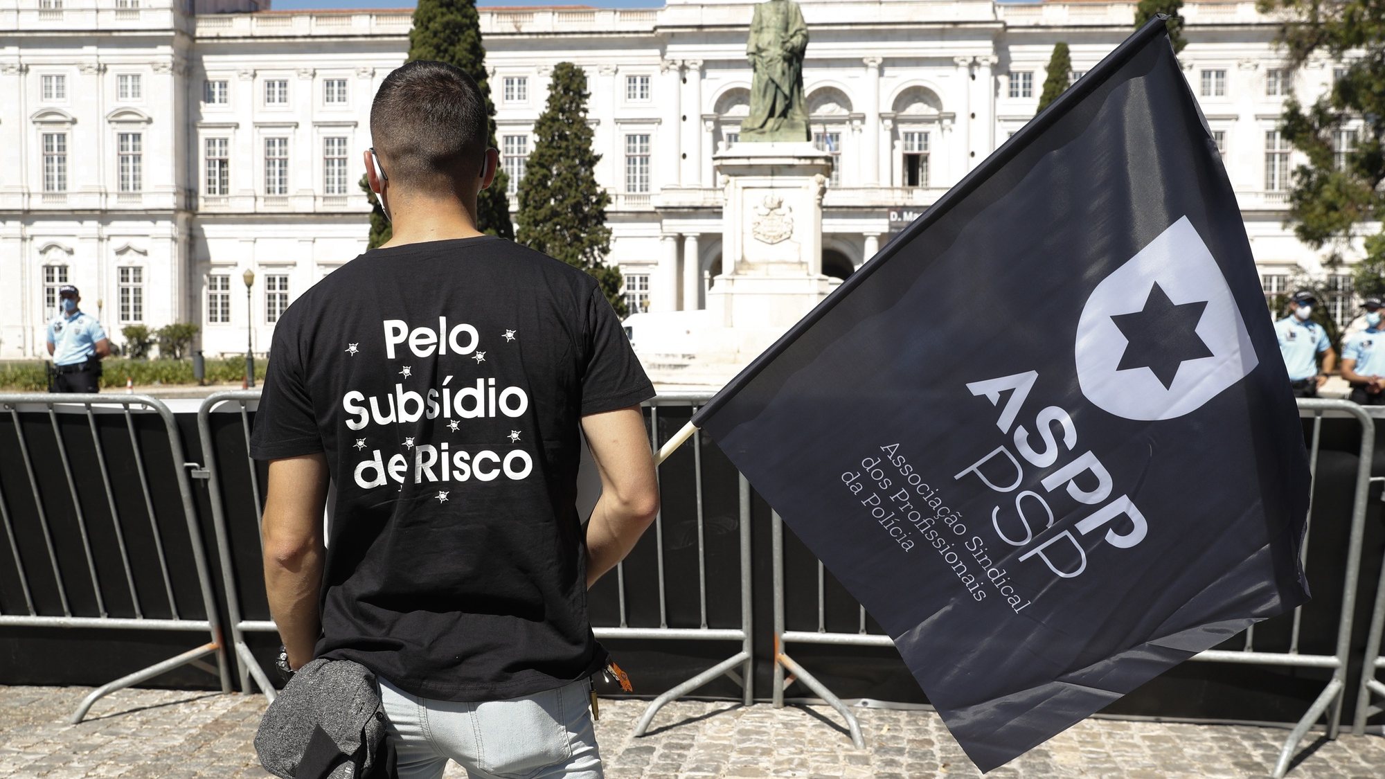 Um participante veste uma t-shirt onde se lê &quot;Pelo Subsídio De Risco&quot; durante a jornada de protesto dos elementos da PSP e da GNR com o objetivo de &quot;sensibilizar todos os cidadãos para a problemática da não atribuição do suplemento de risco aos polícias da PSP e militares da GNR&quot;, junto ao Palácio da Ajuda, local onde decorre a reunião do Conselho de Ministros, em Lisboa, 15 de julho de 2021. Convocado pelos sindicatos da Polícia de Segurança Pública (PSP) e associações da Guarda Nacional Republicana (GNR) - Associação Nacional de Guardas; Associação Nacional de Sargentos da Guarda Associação Sócio Profissional Independente dos Profissionais da GNR; Associação Sindical Autónoma de Polícias; Organização Sindical dos Polícias; Sindicato Independente de Agentes de Polícia; Sindicato Independente Livre Polícia; Sindicato Nacional da Polícia; Sindicato Nacional Carreira de Chefes PSP; Sindicato Nacional Oficiais de Polícia; Sindicato Profissionais de Polícia; Sindicato de Polícia pela Ordem e Liberdade; Sindicato Vertical da Carreira de Polícia. ANTÓNIO COTRIM/LUSA