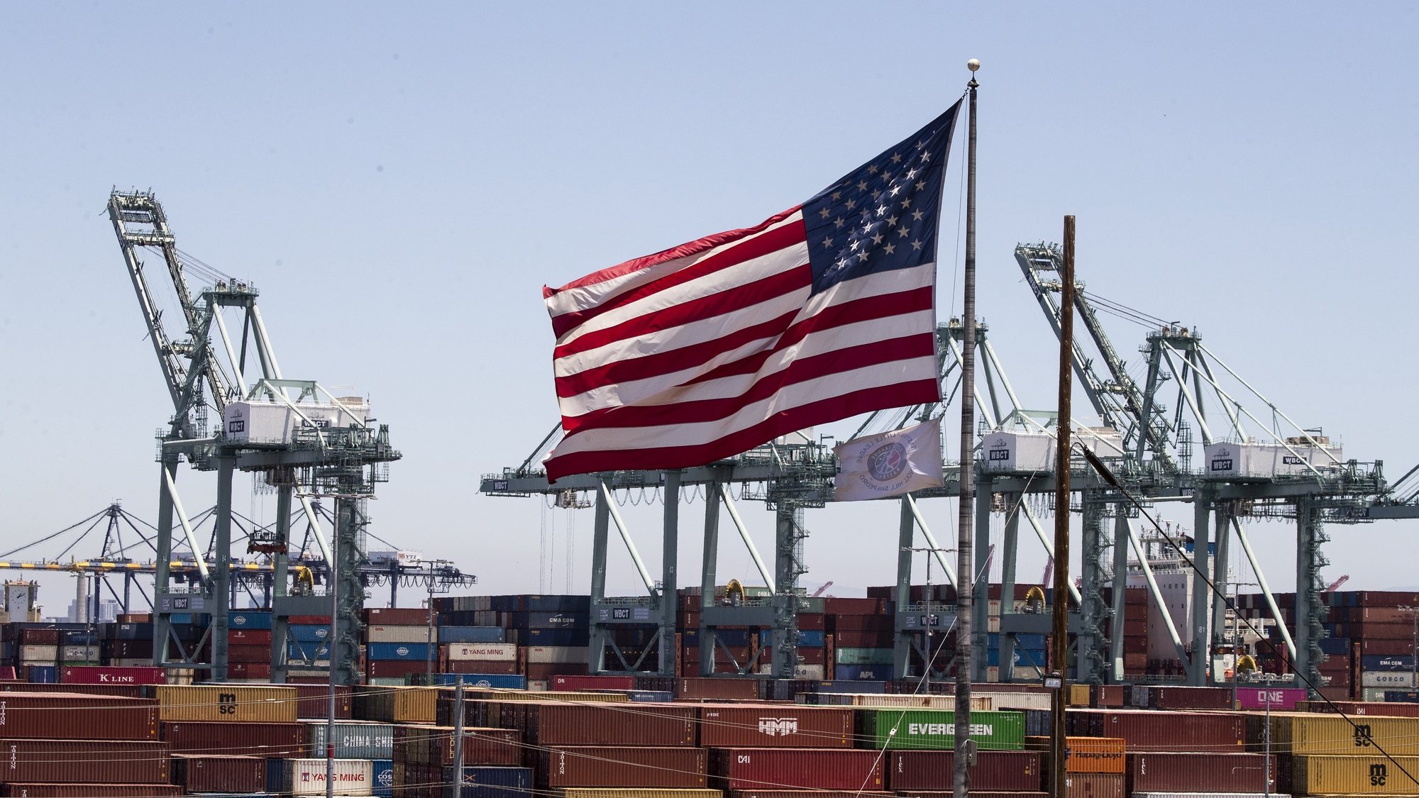 epa10058234 The US flag towers above hundreds of containers the Port of Los Angeles, California, USA, 07 July 2022. The first wave of the previous administration&#039;s tariffs on imports of Chinese goods began four years ago, and the US President is weighing options to continue the tariffs, according to reports. The tariffs imposed on China include a broad range of items; including steel and aluminum products, semiconductors, aircraft parts, motorcycles, fabric, furniture, clothing and more.  EPA/ETIENNE LAURENT