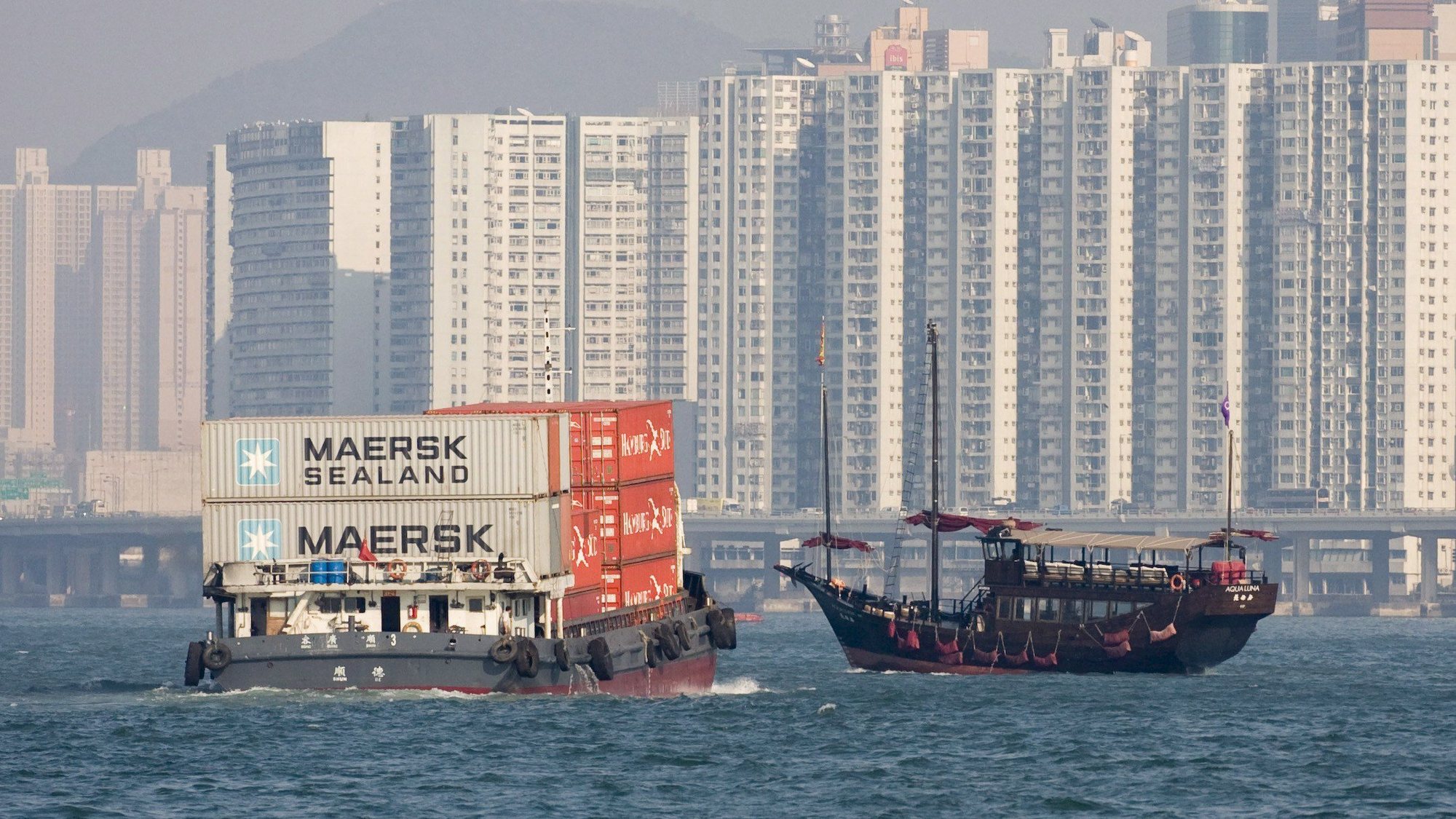 epa01171164 A traditional junk passes a barge carrying containers in the harbour of Hong Kong, China on 12 November 2007, where property is amongst the most expensive in the world. Major property developers lost as much as 7 percent in value on the Hong Kong stock market, 12 November as the mainland central bank, People&#039;s Bank of China (PBOC), raised lending rates for the ninth time this year aiming to cool a generally overheating economy.  EPA/ADRIAN BRADSHAW